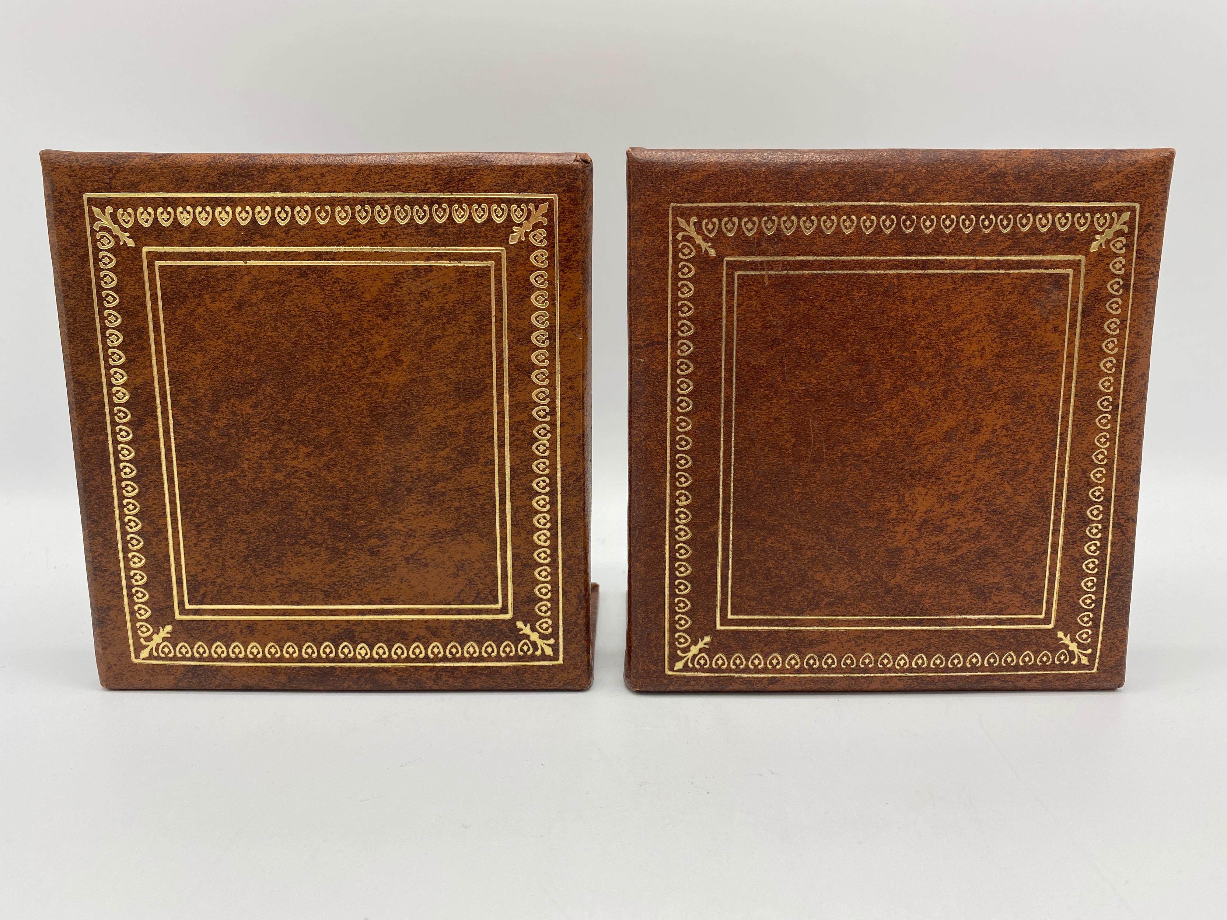 Listed is a stunning and sophisticated, pair of Italian leather bookends, circa 1960s. The pair have a beautiful, marbled brown leather and are accented by a gold debossed border on the outer facing sides. Internal metal framing along the base,