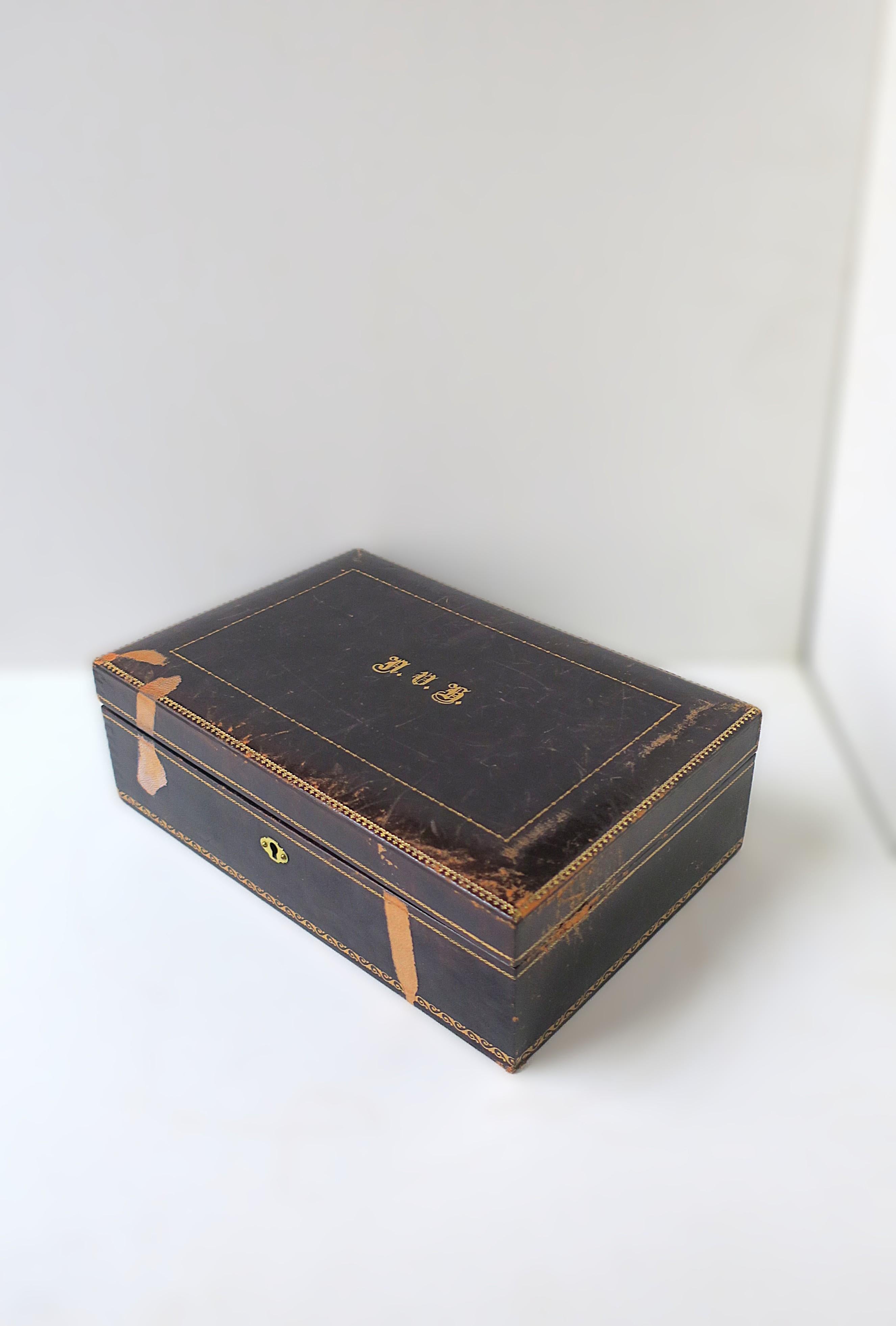 Boîte à bijoux italienne en cuir bleu foncé et or avec plateau amovible, vers le début ou le milieu du XXe siècle, Italie. La boîte en cuir est bleu foncé - un cuir bleu encre avec un bord décoratif de gaufrage/outillage doré sur le dessus, le bord,