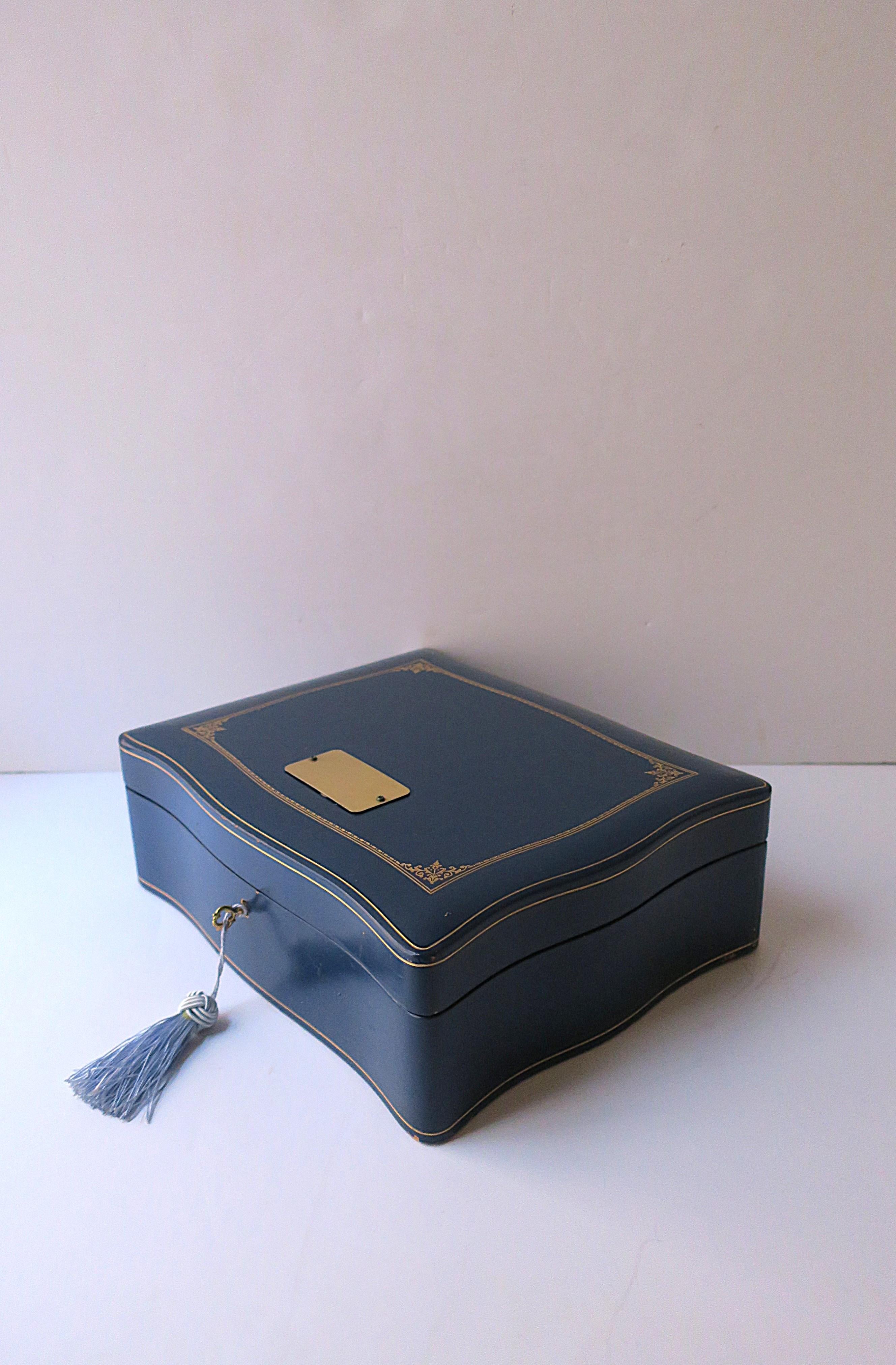 Joyero italiano de cuero azul y dorado con bandeja extraíble y llave/cerradura, hacia mediados del siglo XX, Italia. La caja de cuero es de cuero azul con borde decorativo, grabados dorados en la parte superior, el borde, la base y el interior,
