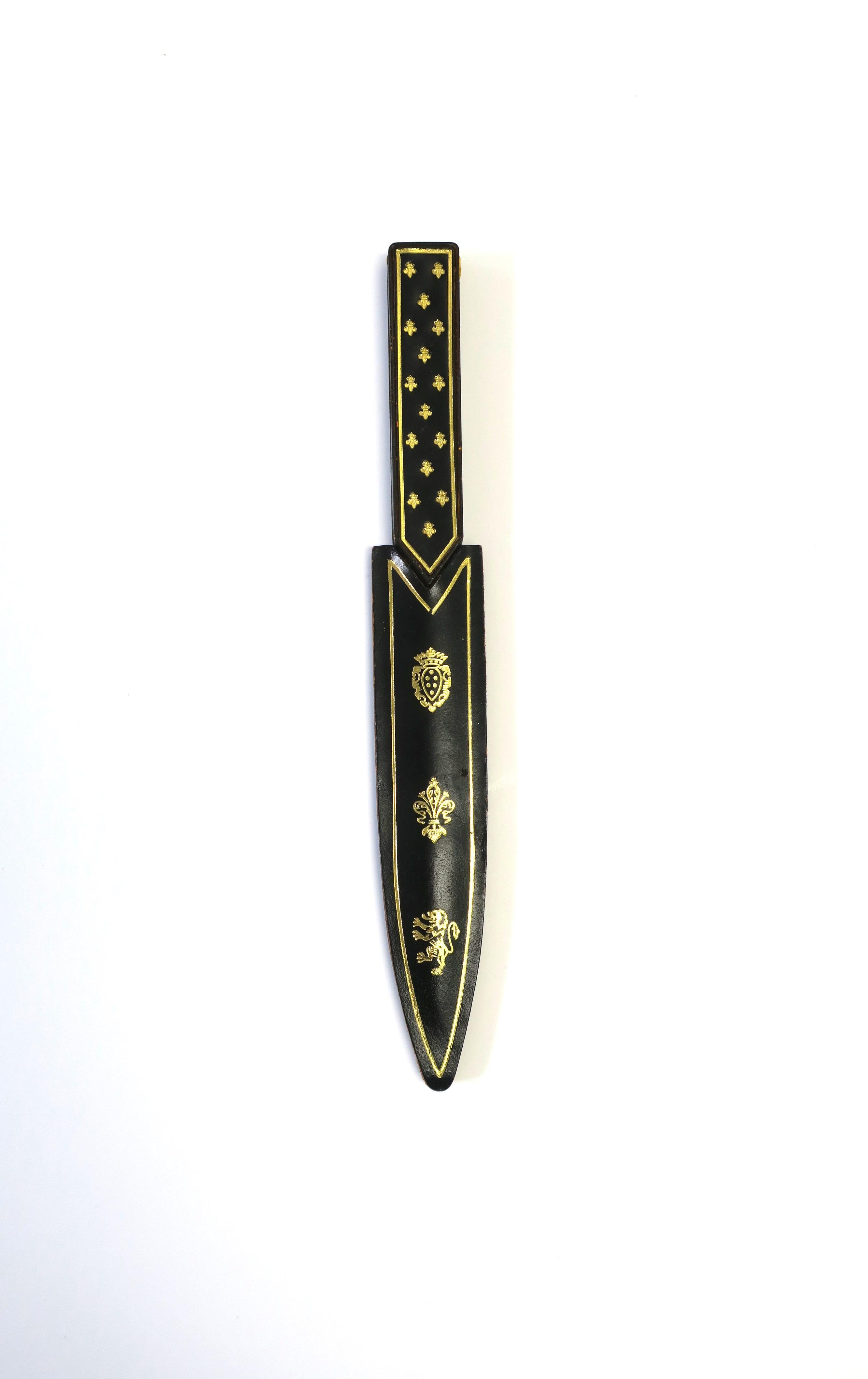 An Italian leather gold embossed and resin letter opener, circa mid-20th century, Italy. Piece is black leather with gold embossed regal design and a translucent brown knife opener. Marked 'Made Italy' on acrylic/resin knife area, near handle, as