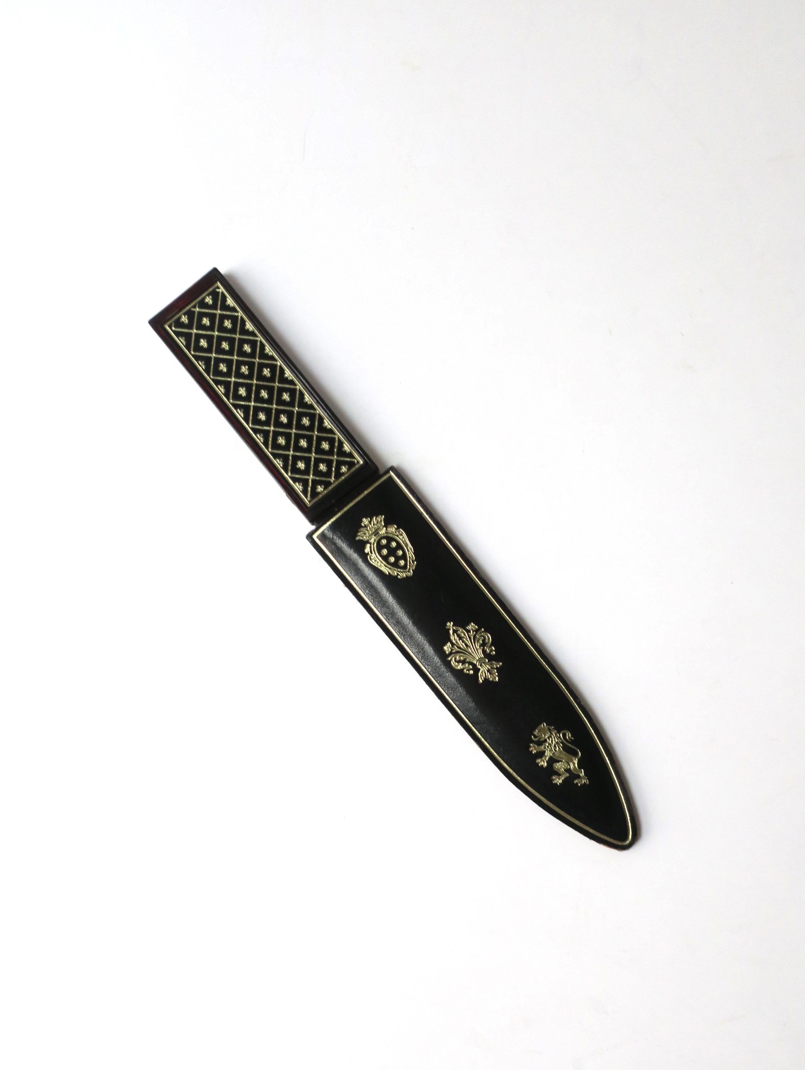 An Italian black leather gold embossed resin letter opener, circa mid-20th century, Italy. Piece is black leather with gold embossed regal design and a translucent resin brown knife blade. Marked 'Made Italy' on acrylic/resin knife area, near