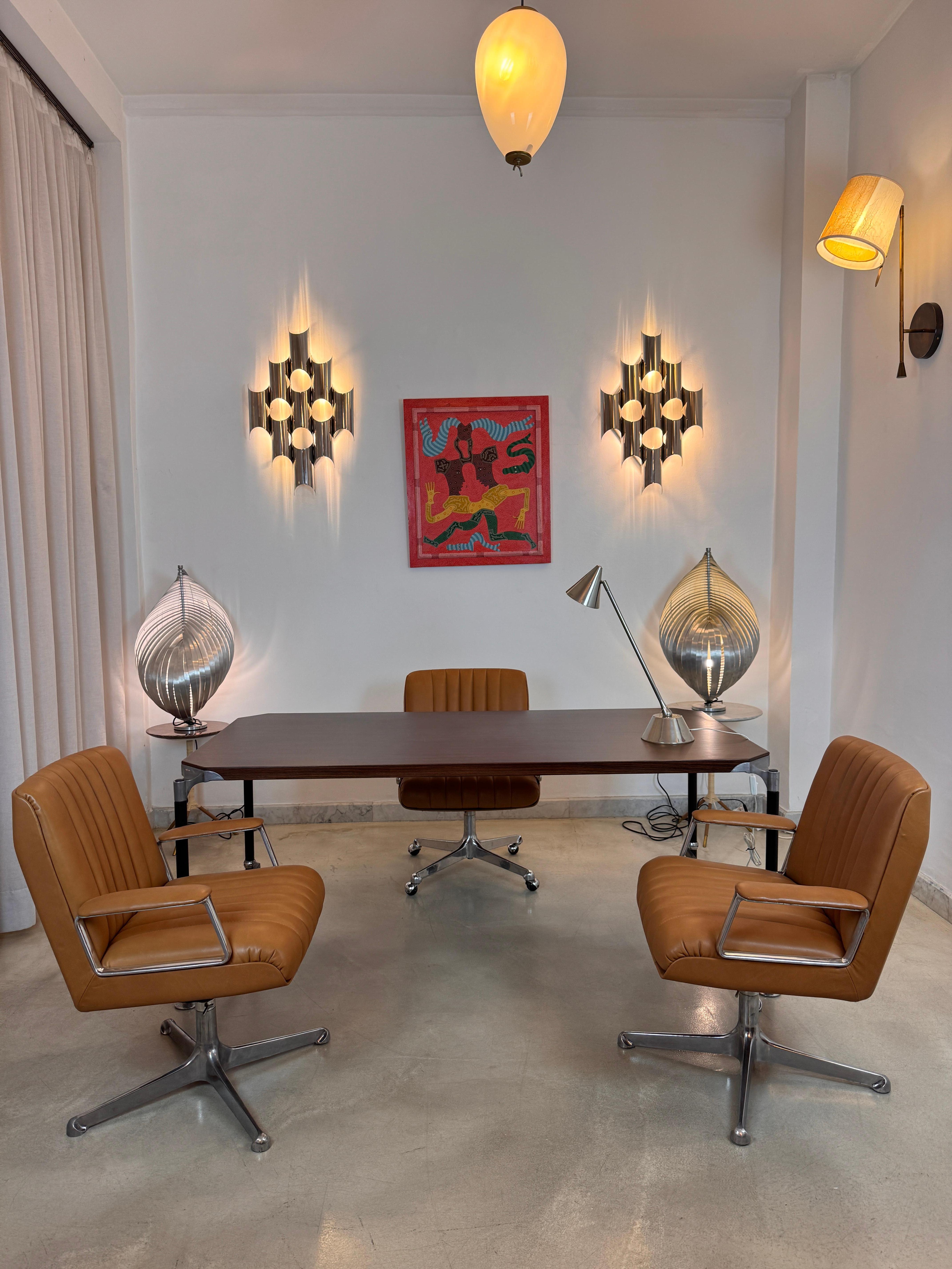 Presenting an expertly restored set of three Osvaldo Borsani office chairs, including an executive model and two visitor chairs. Each chair has been meticulously refurbished with new tan-brown Italian leather. All are height adjustable and