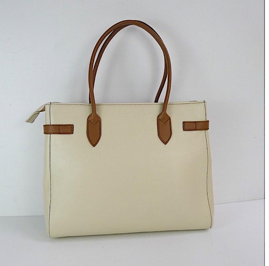 A large fine Stylish Italian leather handbag with a chrome lock and hanging leather key holder.
 Made by designer Diane B, Milano. Beige leather with double Brown handles. Interior is a taupe leather with lots of compartmented storage. Center zipper