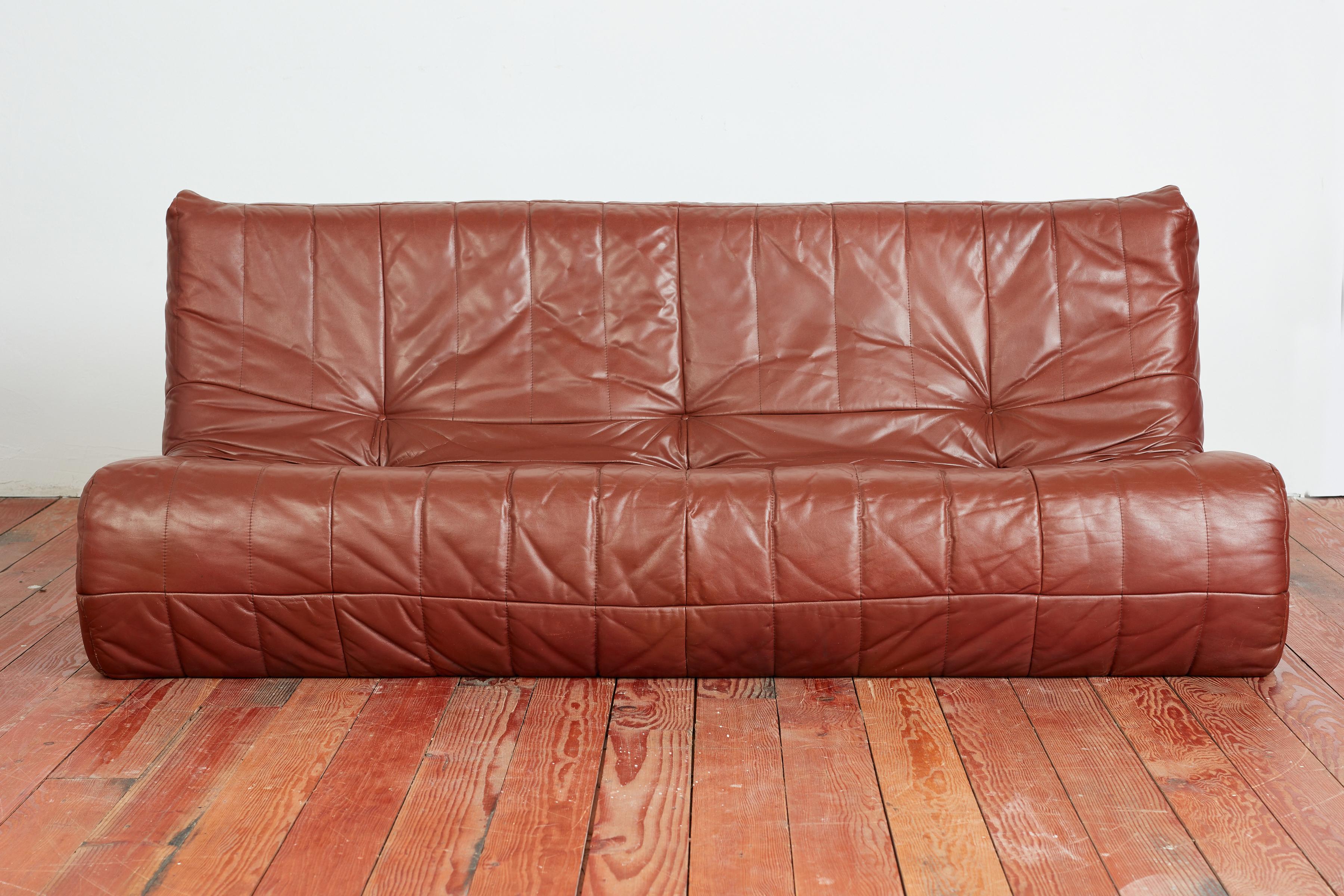 1970's Italian leather settee in the style of a TOGO- with foam core and wrapped with cognac colored leather with vertical stitching.  Italy, 1970's  Matching sofa available

Matching Settee Available 