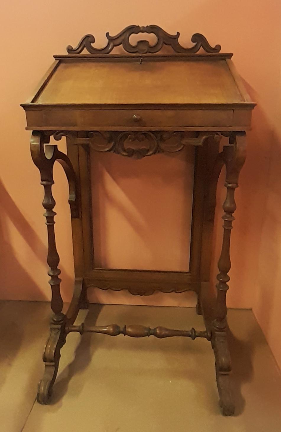 Lectern in cherry wood from the Louis Philippe period (mid 19th century) of Italian origin. 

This kind of lecterns used to be placed near archives, bookshops and libraries. 
Of contained measures and with carved ornamental friezes, it denotes how