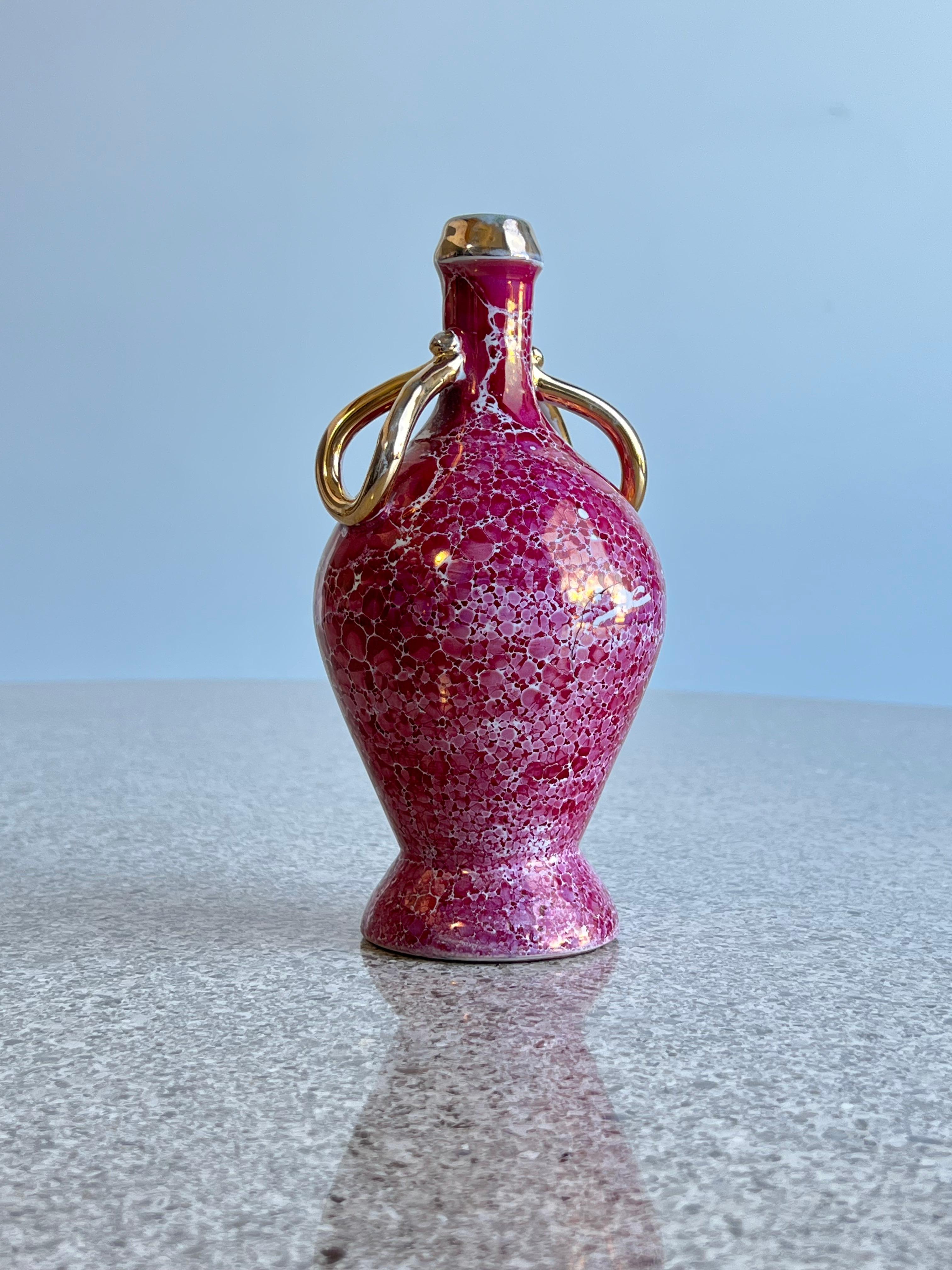 Italian Limoges Porcelain Burgundy and gold 1970s.
Incredible 20cm high vase with gold hand paint art work, probably made to serve olive oil or vinegar on the tables 1950s Italian dinner tables. 
  