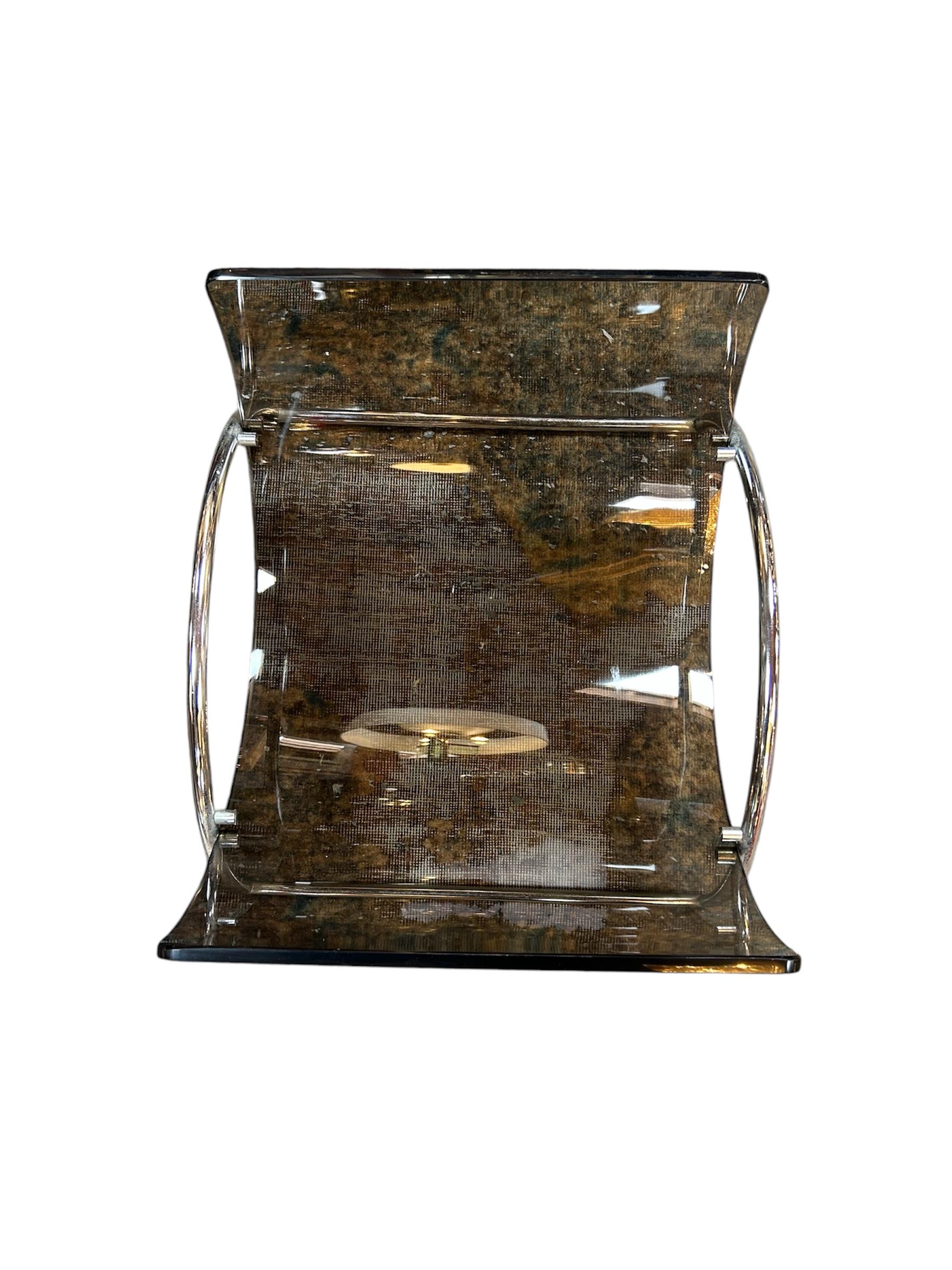 Designed by Pierangelo Gallotti for Gallotti & Radice in the 1980s, the Italian Lira magazine rack features curved smoked Lucite panels and a polished chrome frame—an iconic blend of modern and futuristic design.