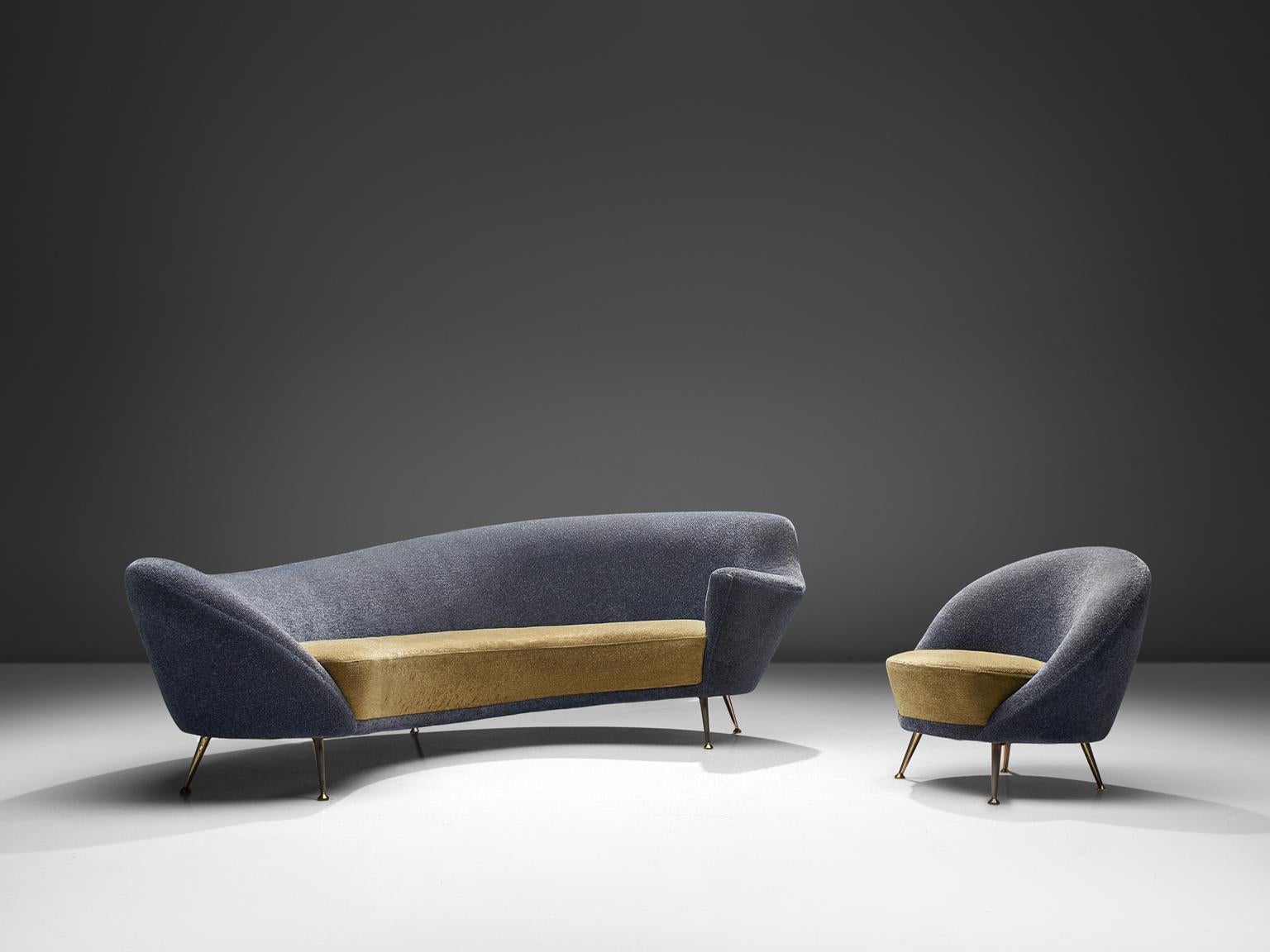 Curved sofa and easy chair, yellow and blue fabric, brass, Italy, 1950s.

This elegant set features a dynamic sofa with an a-symmetrical back and a club chair. The back of the sofa is higher on the right side and slowly slopes towards much lower