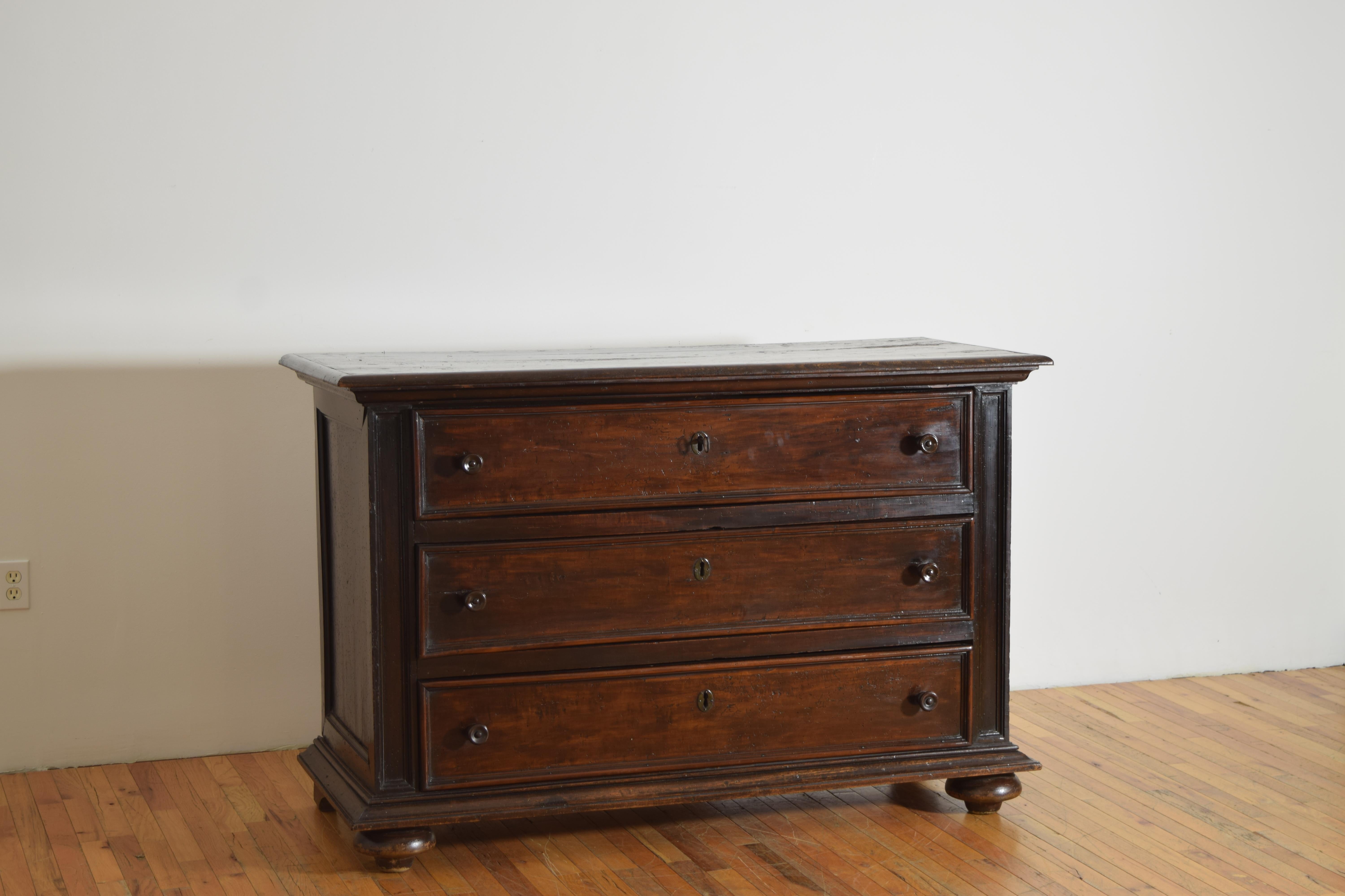 having a rectangular top with a curved molded edge atop a conforming case housing three large drawers between molded pilasters, the plinth-form base raised on flattened bun feet