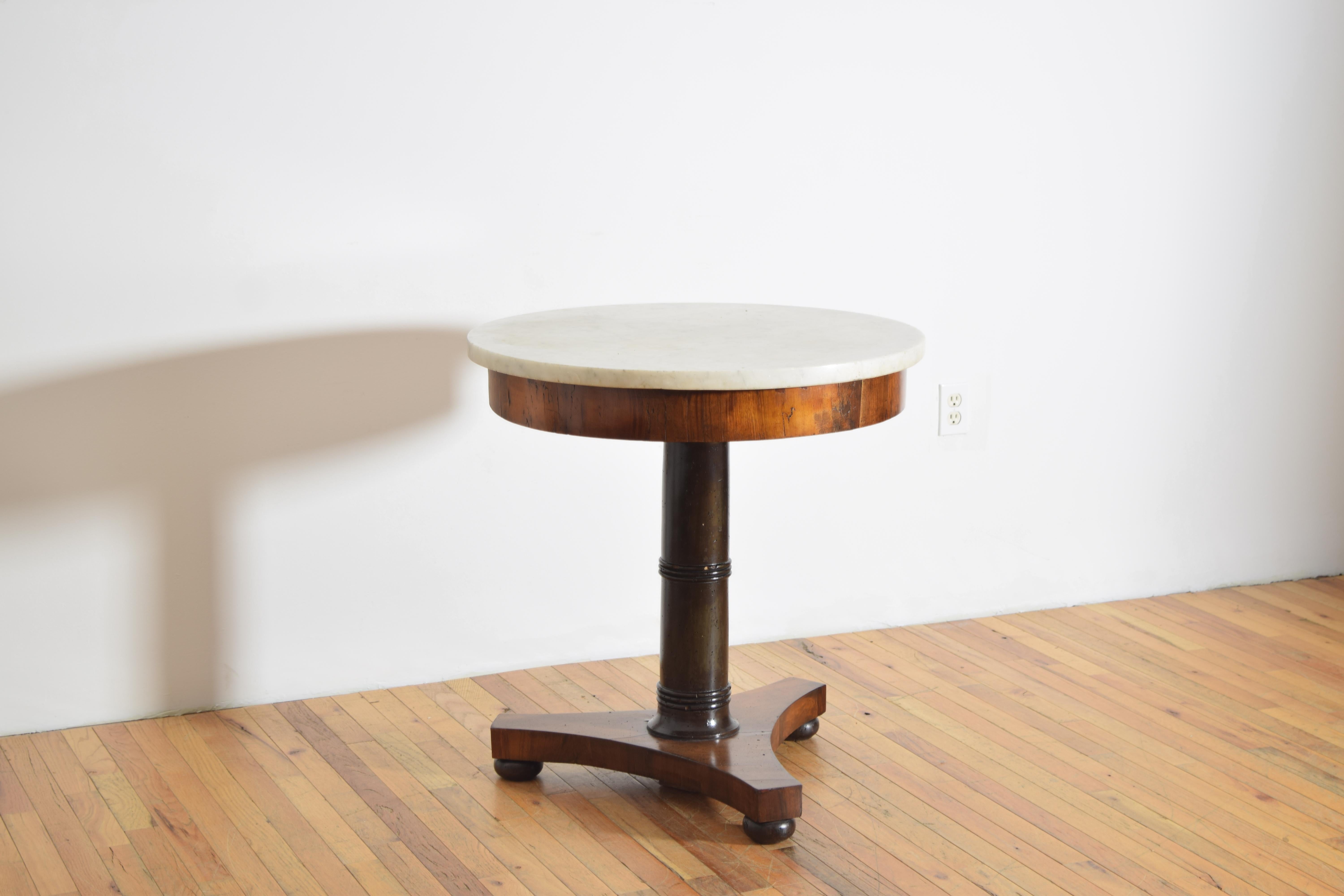 retaining its original Carrara marble circular top resting on a veneered walnut frame raised on a solid ebonized turned wooden standard, the tripartite base is veneered in walnut and raised on solid walnut compressed bun feet