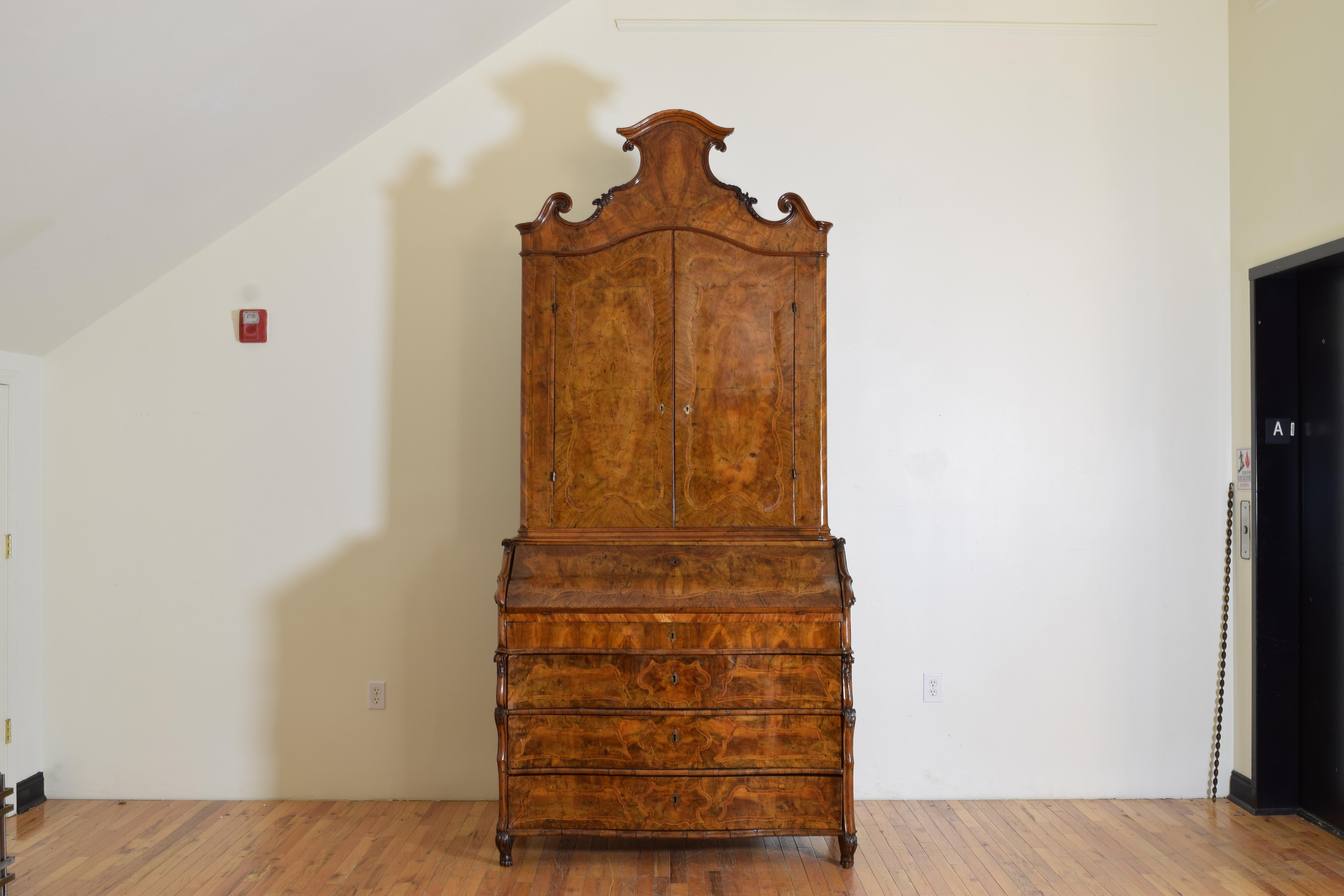 Constructed in the opulent style of Milan, Italy during the mid 18th century this two piece cabinet features a bookshelf in the top section and a fold-down secretary with drawers below, the entire outer and secretary portion covered in rich walnut