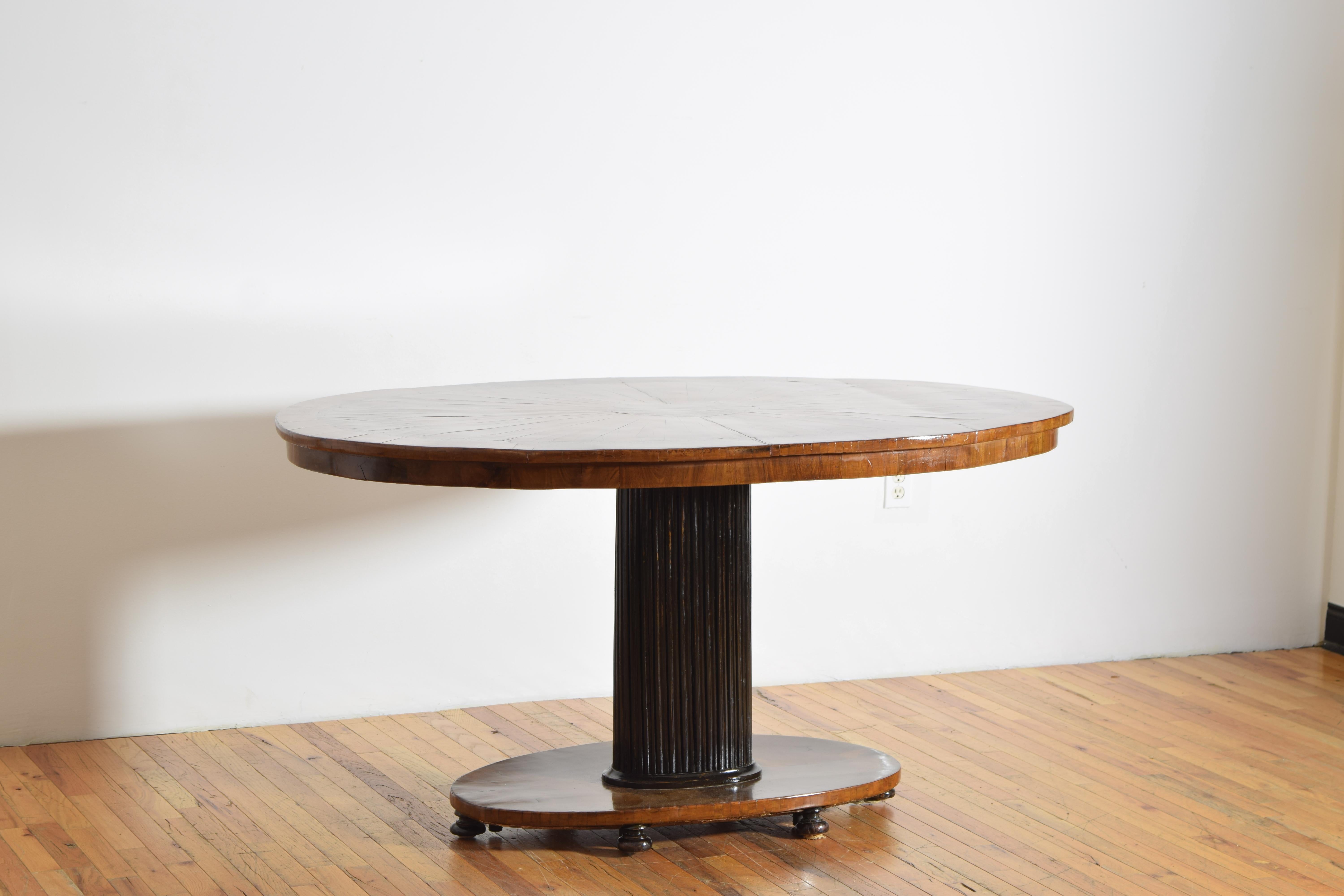 mit einer ovalen Platte, die wunderschön in einem Sonnenschliff-Muster mit einem zentrierten Oval furniert ist, der äußere Rand mit einem eingelegten Band und mit einer flachen furnierten Schürze, die auf einem ovalen kannelierten und ebonisierten