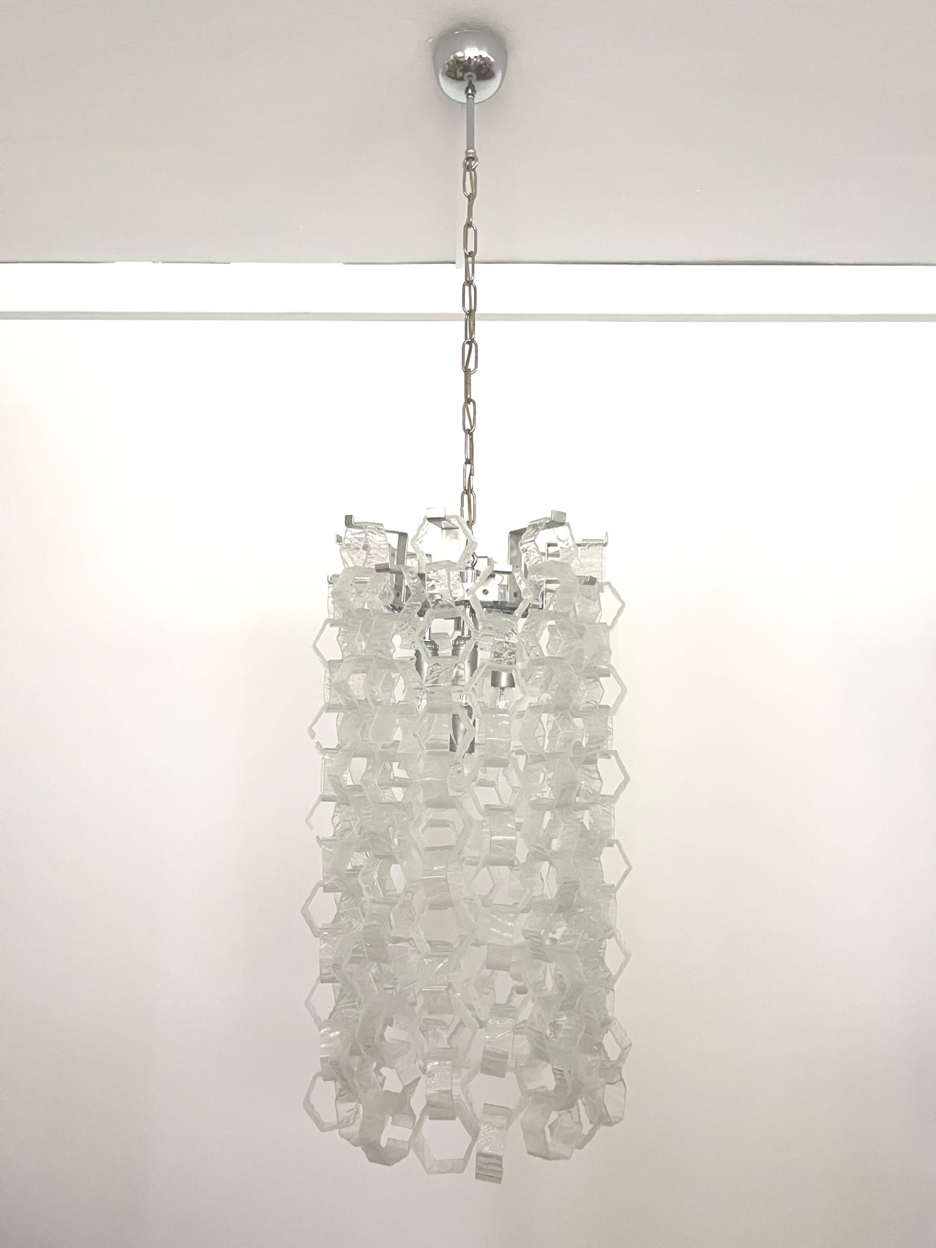 Beauty and stunning Interlocking Murano glass Chandelier by Carlo Nason for Mazzega. This Chandelier was designed and manufactured during the 1970s in Italy. 
This chandelier is composed by 200 units of clear hexagon Murano glasses and metal