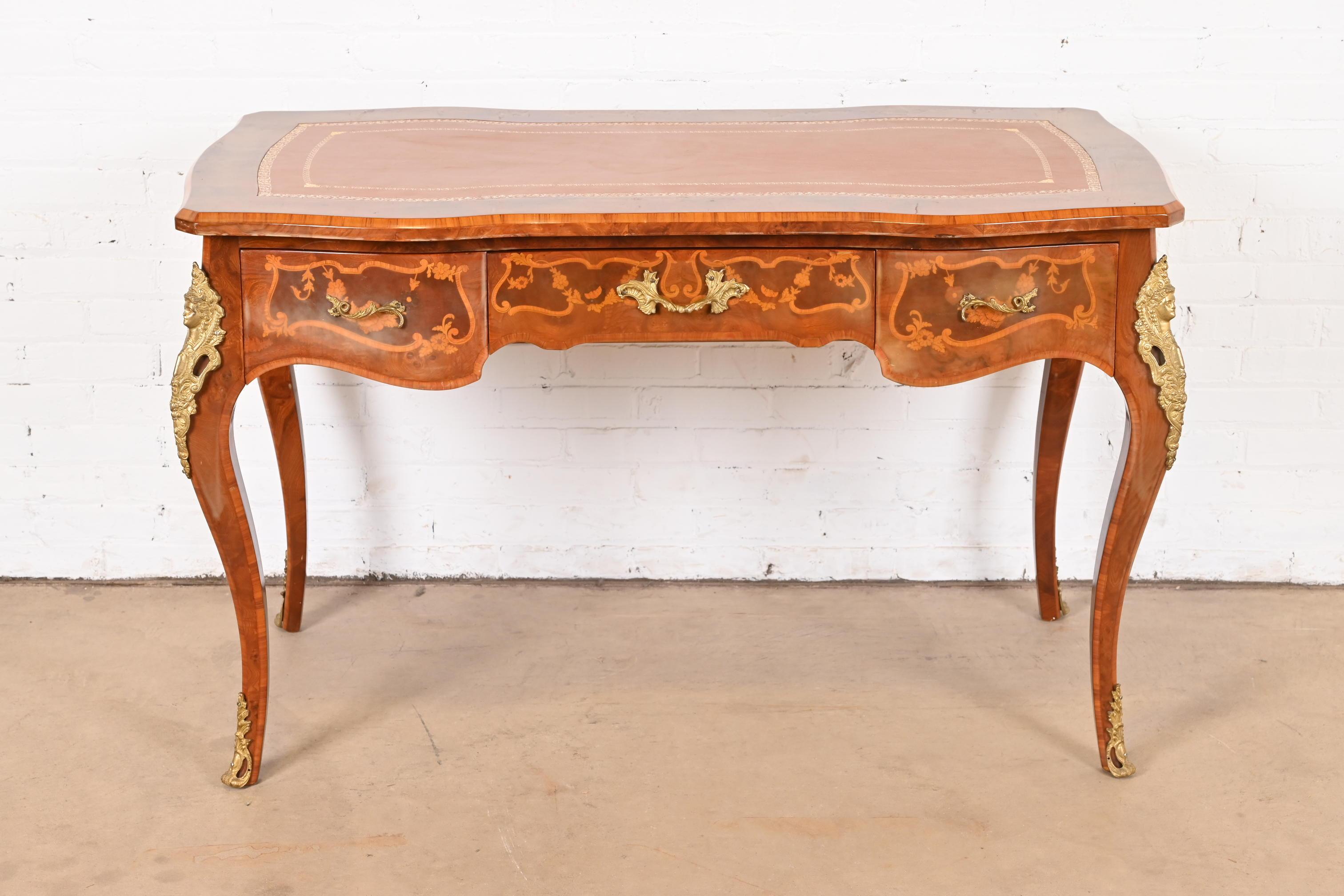 An outstanding Italian Louis XV style writing desk or bureau plat desk

Italy, Circa 1940s

Gorgeous burl wood, with inlaid marquetry, ornate ormolu mounts, and embossed brown leather top.

Measures: 51.25