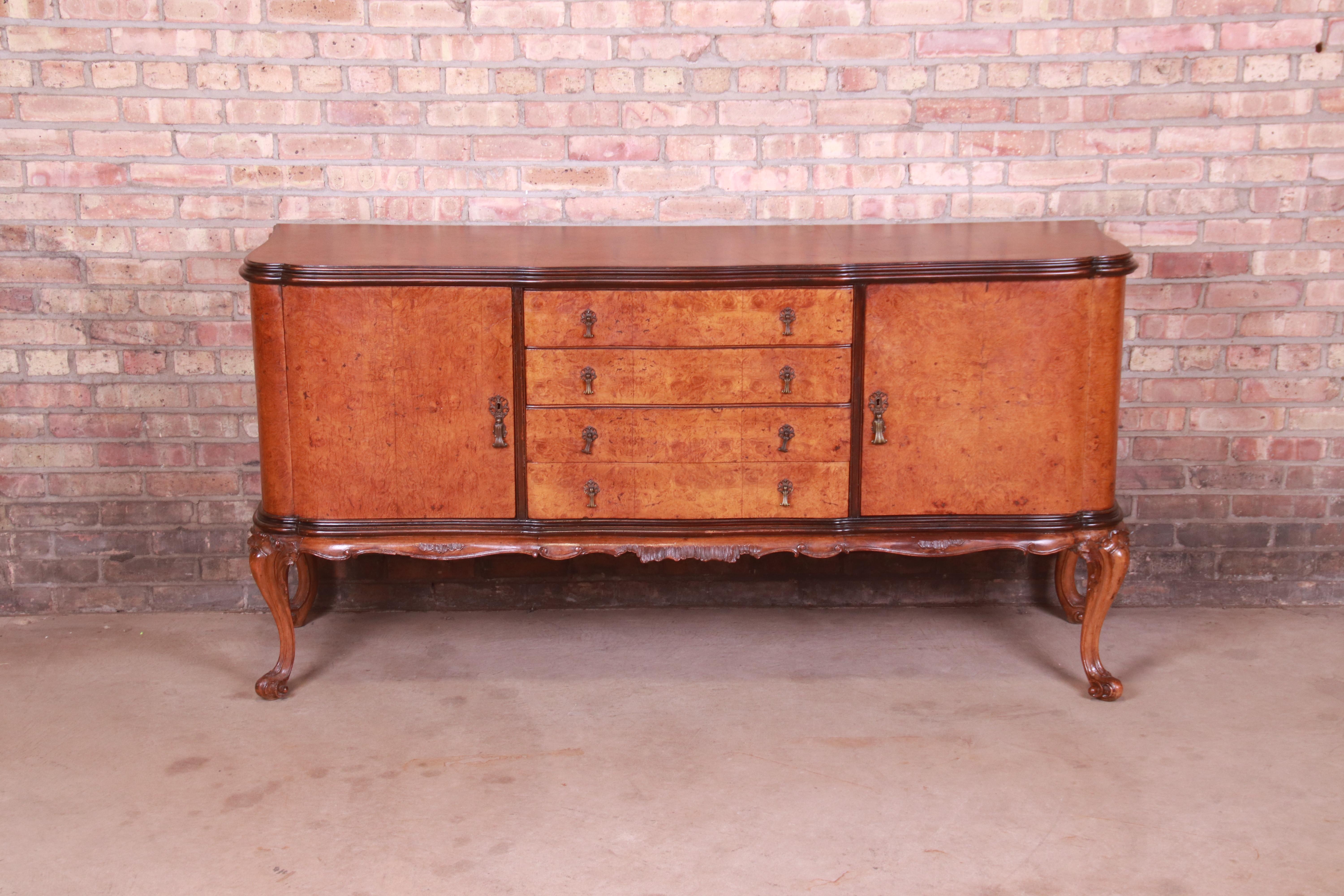 A gorgeous Italian Louis XV style sideboard, credenza, buffet server, or bar cabinet

Italy, Circa 1940s

Stunning burled olive wood, with carved walnut legs and original brass hardware.

Measures: 72