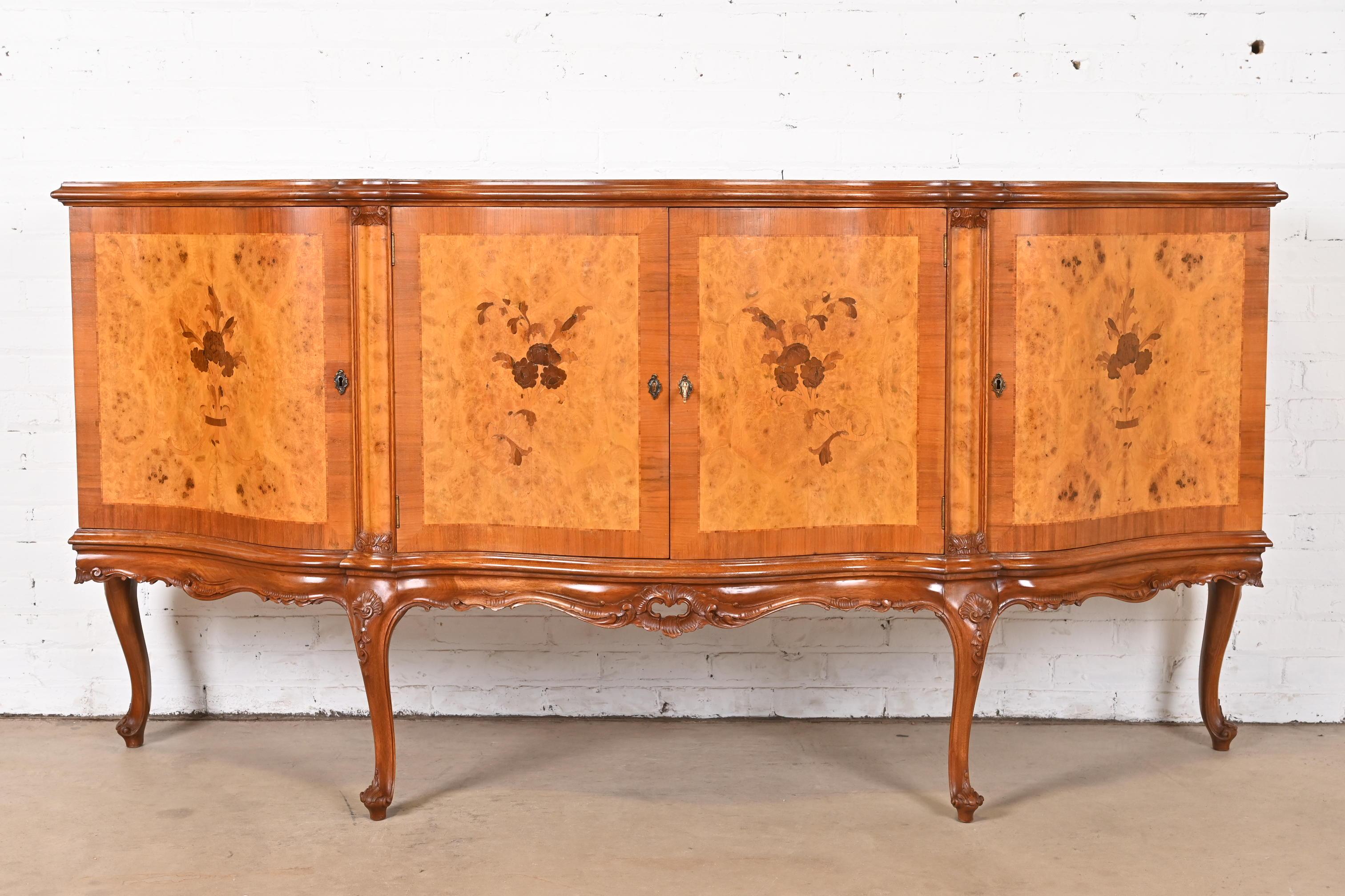 A gorgeous Italian Louis XV style sideboard, credenza, buffet server, or bar cabinet

Italy, Circa 1940s

Stunning burled olive wood, with inlaid floral marquetry, carved walnut legs and brass hardware. Cabinet locks, and key is included.

Measures: