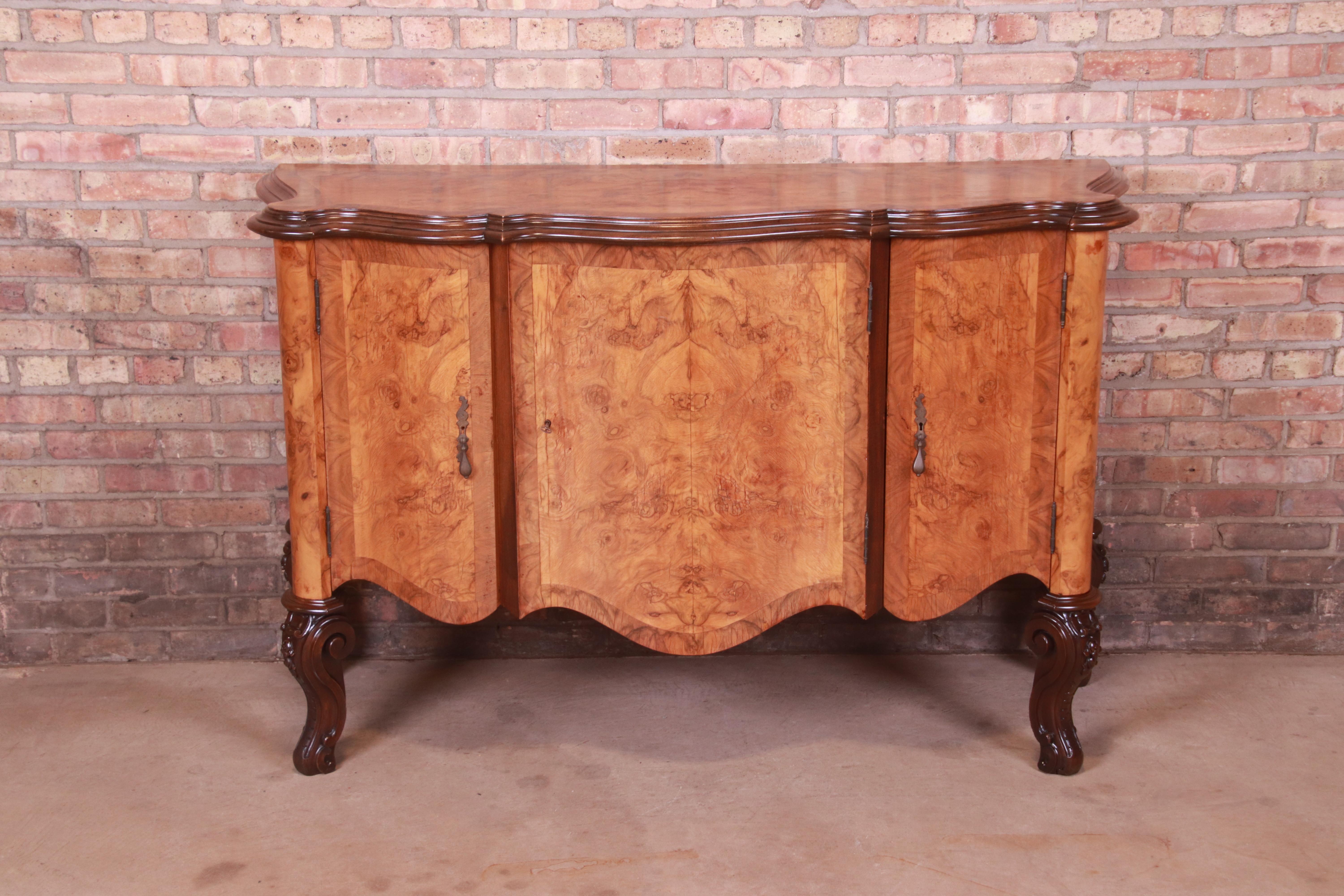 A gorgeous Italian Louis XV style sideboard, buffet server, or bar cabinet

Italy, Circa 1940s

Stunning burled olive wood, with carved mahogany legs and original brass hardware.

Measures: 60.5