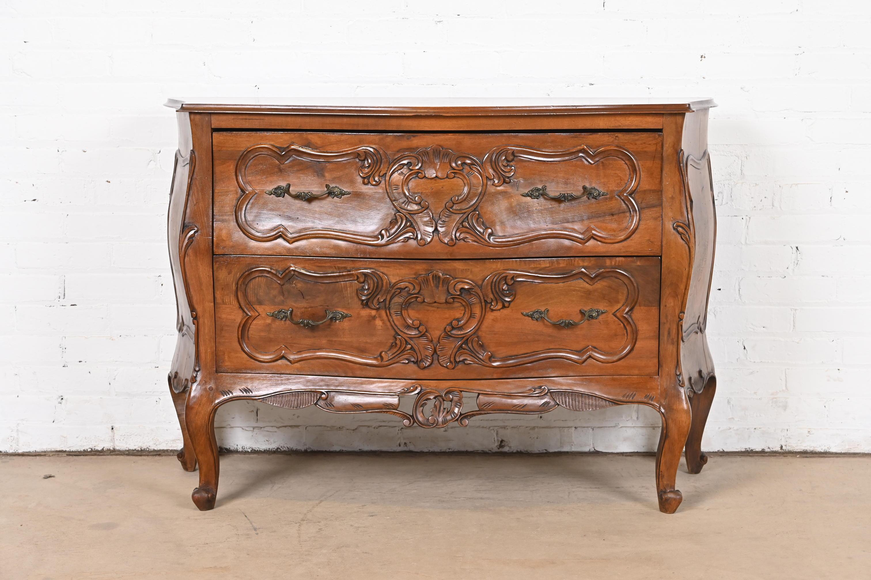 A gorgeous Italian Rococo or Louis XV style bombay chest, commode, or chest of drawers

In the manner of Baker Furniture

Italy, Late 20th Century

Carved walnut, with original brass hardware.

Measures: 45.5