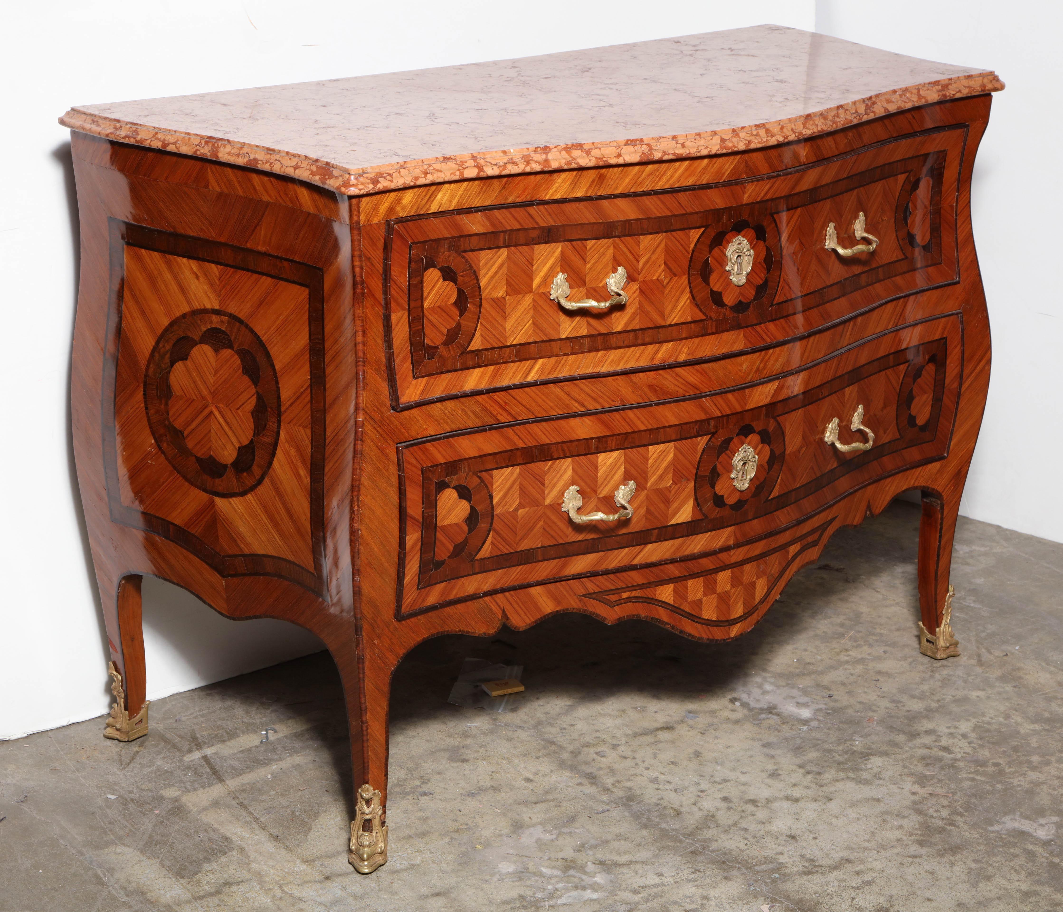 Italian Louis XV marble top bombe and serpentine two-drawer commode with parquetry inlays, bronze mounts and sabots.