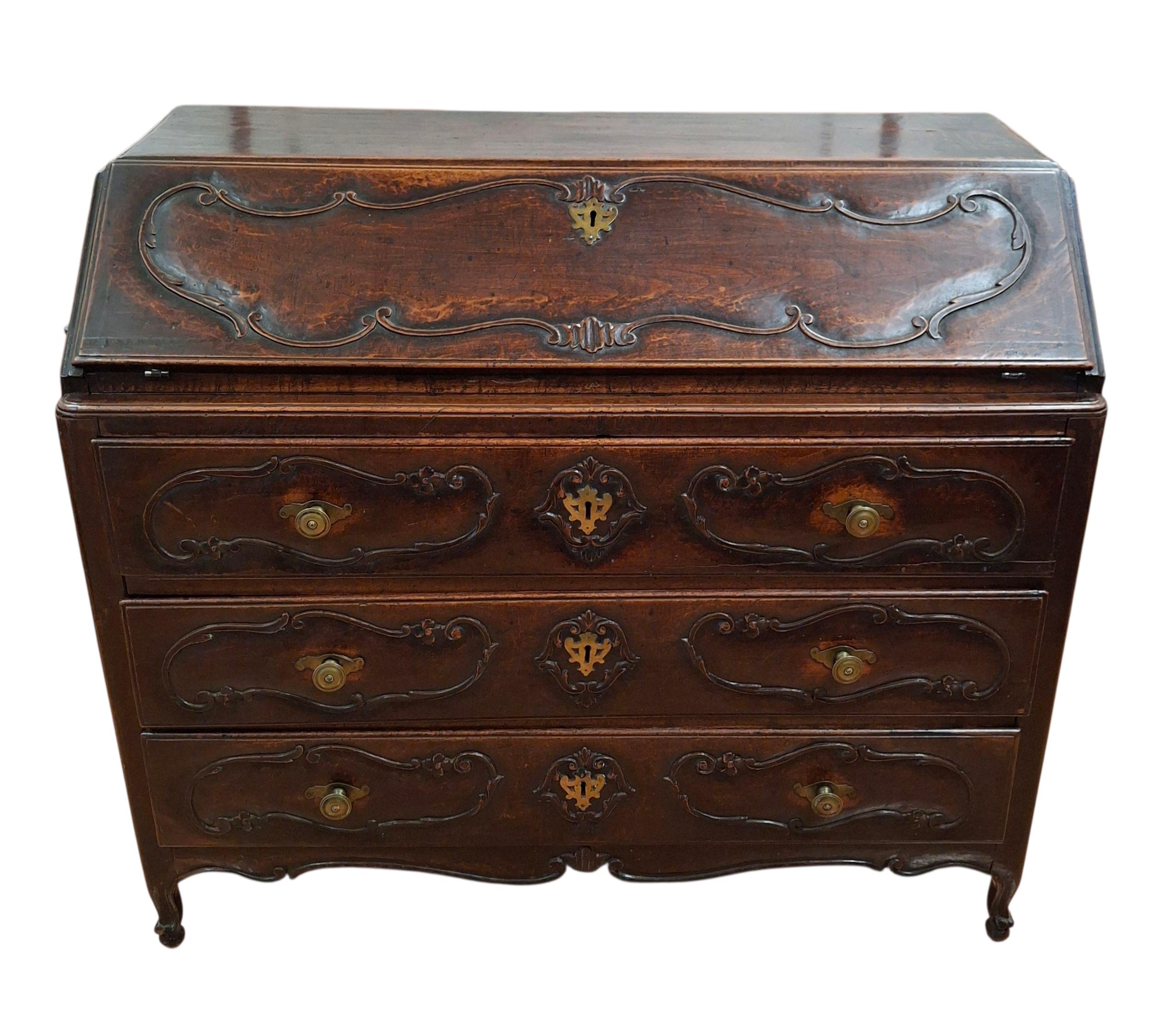 Secrétaire/bureau italien de style Louis XV, vers 1740.  La façade en biais s'ouvre sur quatre tiroirs, au-dessus de l'étui sculpté en relief qui conserve sa finition très ancienne, ses façades sculptées, ses ferrures d'origine et repose sur des