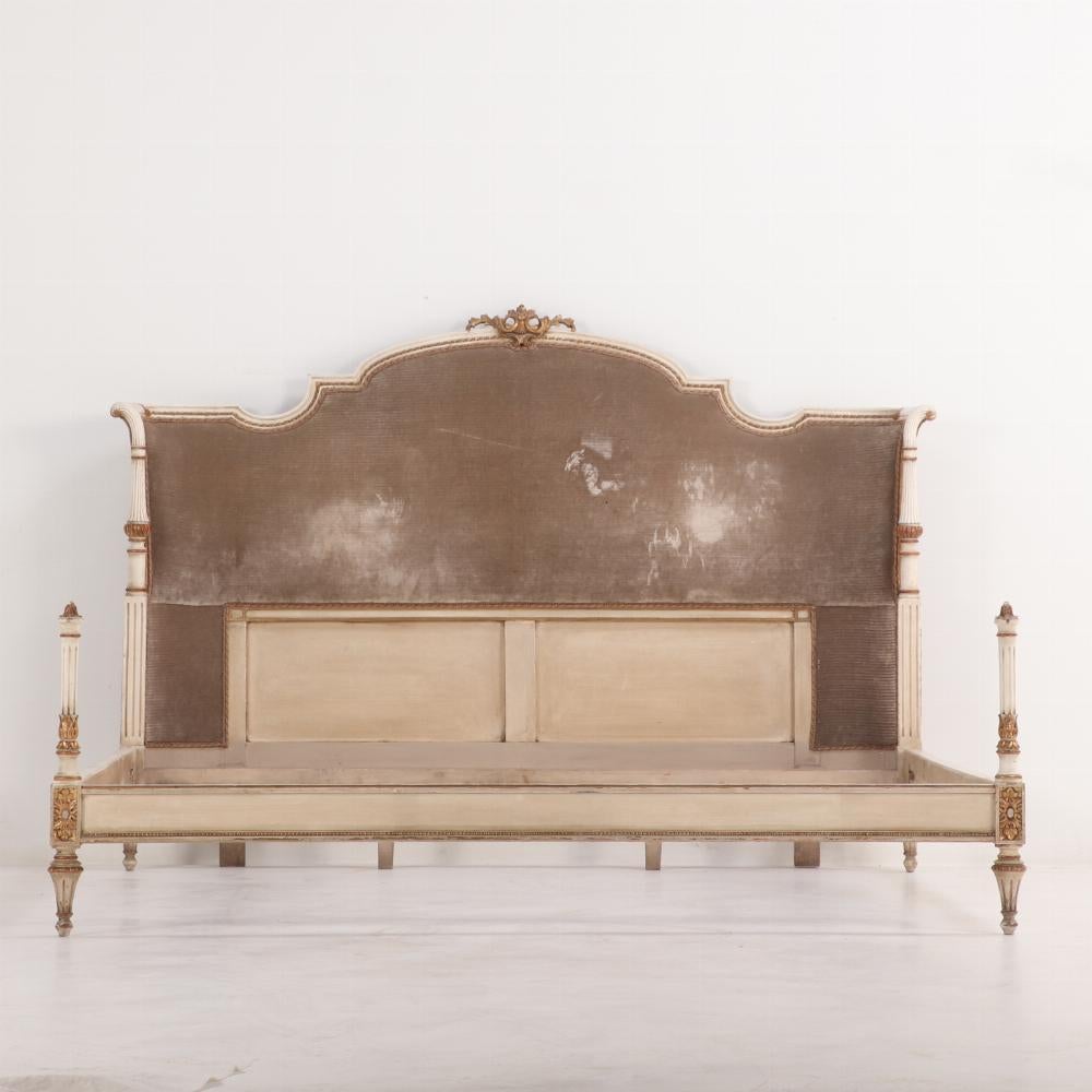 Italian Louis XV style painted and gilt bed C 1920 having a wrap around headboard with carved columns and a gilt carved cartouche. Queen width. Interior Dimensions: 66