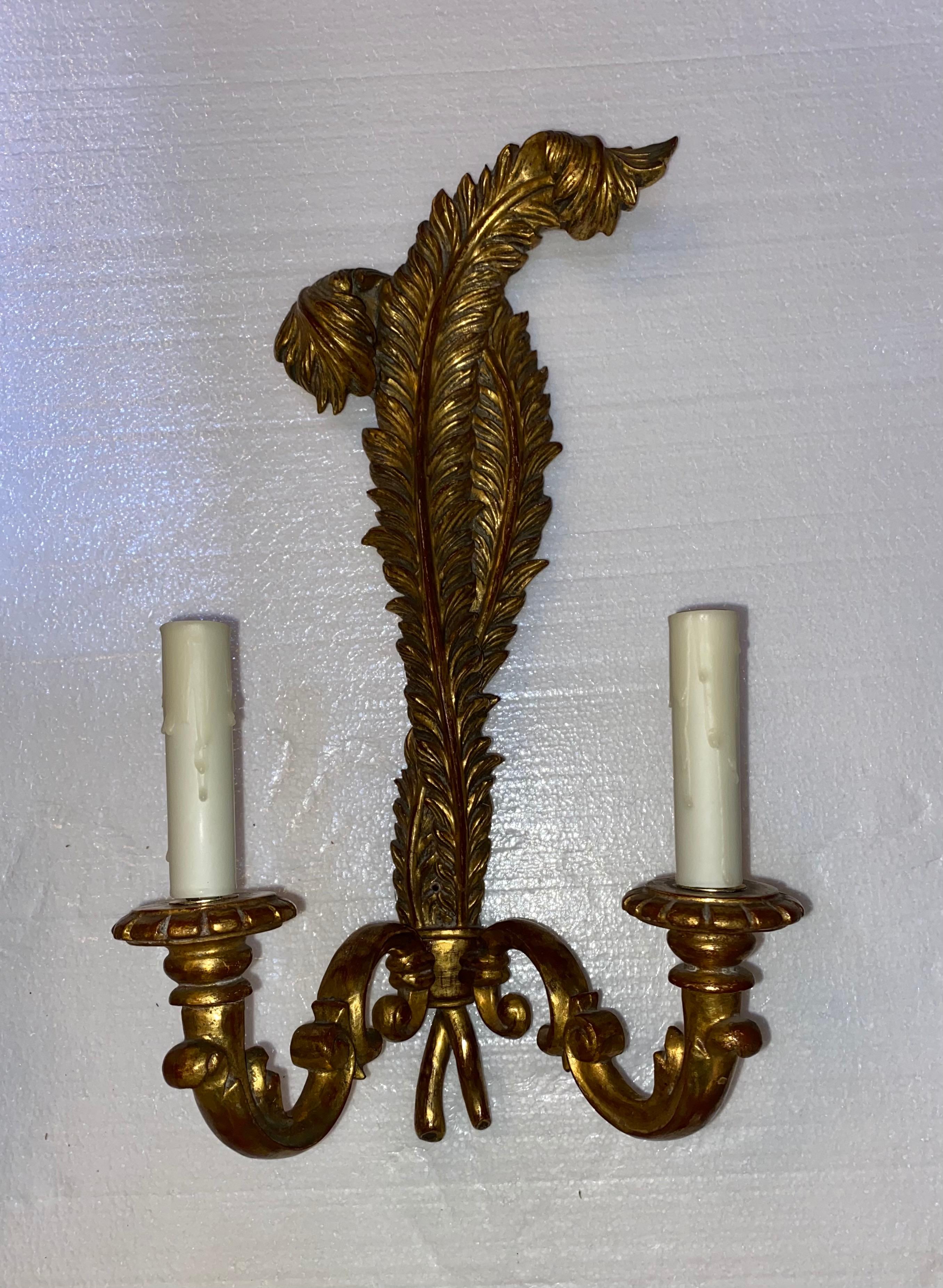 Italian Louis XV style giltwood wall sconces, 20th c., undulating feather-form wall mount supporting two foliate scroll arms ending in bobeches and faux candles.