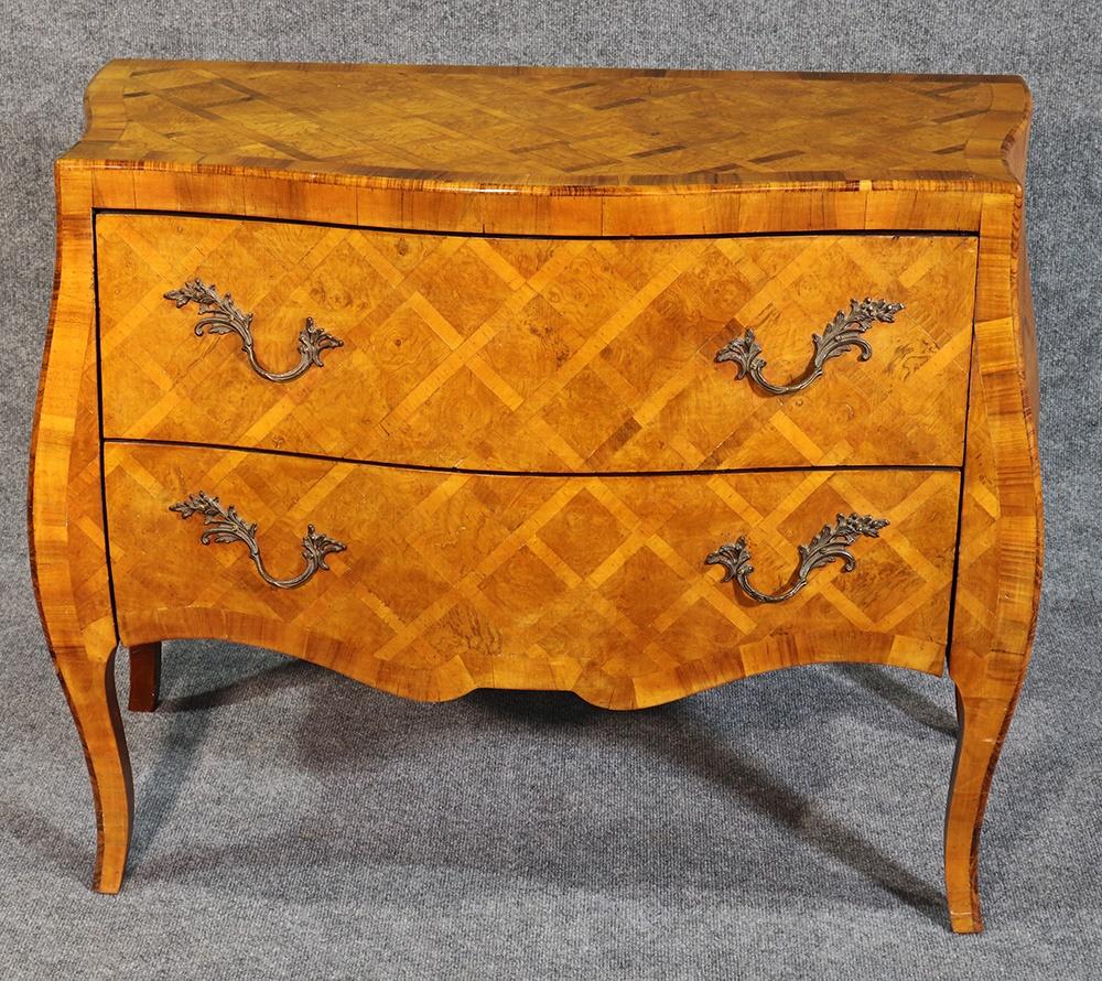 This is a gorgeous and simple commode. Made in Italy during the 1940s, this beautiful 2-drawer olivewood commode features cross-banded inlay. The styling is a simplified Louis XV.