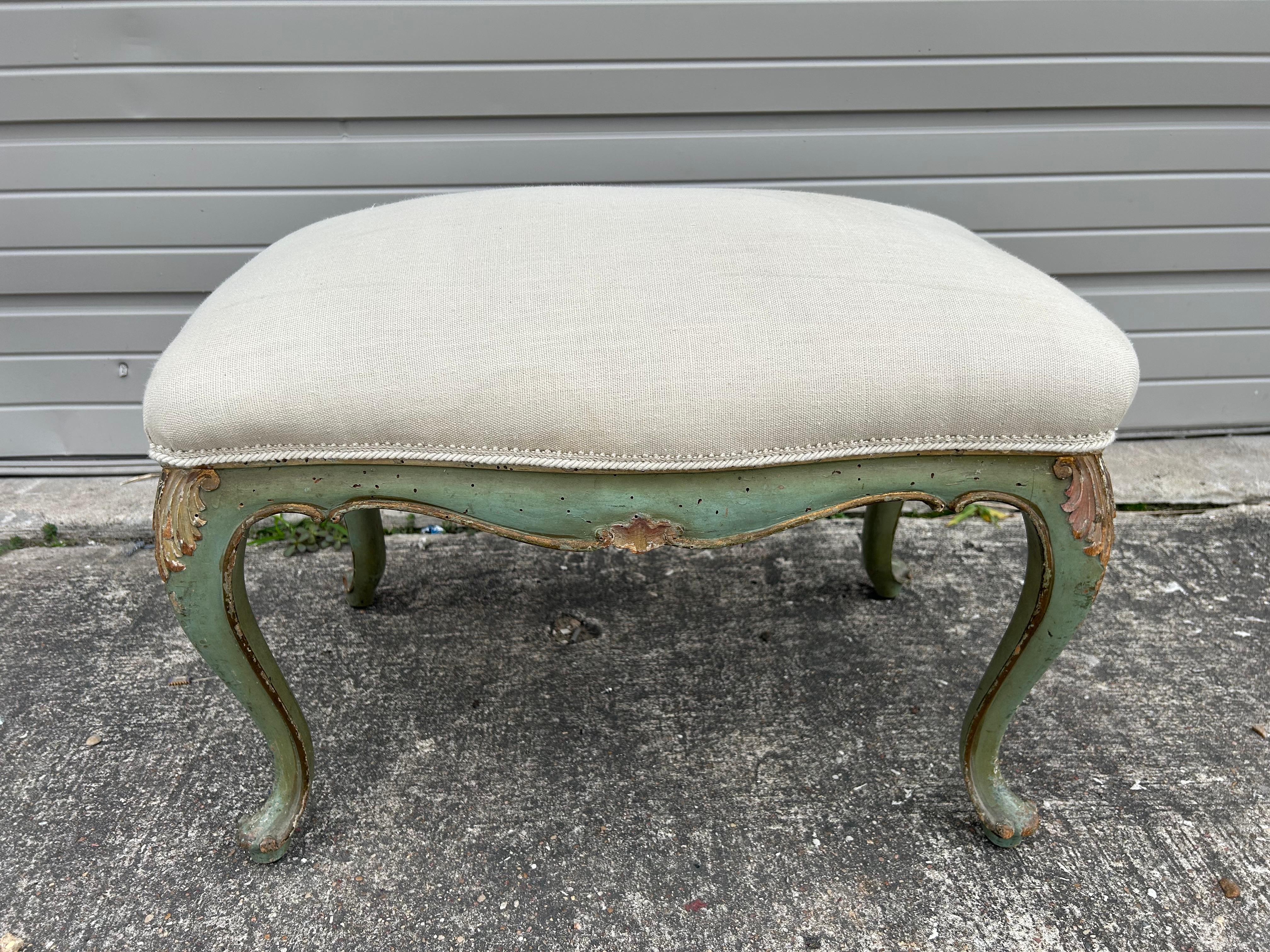 Italian Louis XV Style Painted And Gilt Bench.
Offered is a lovely Italian painted and gilt wood bench or ottoman.
The finish is a lovely soft green with gilt accents and is currently upholstered in 
neutral linen and ready for the fabric of your
