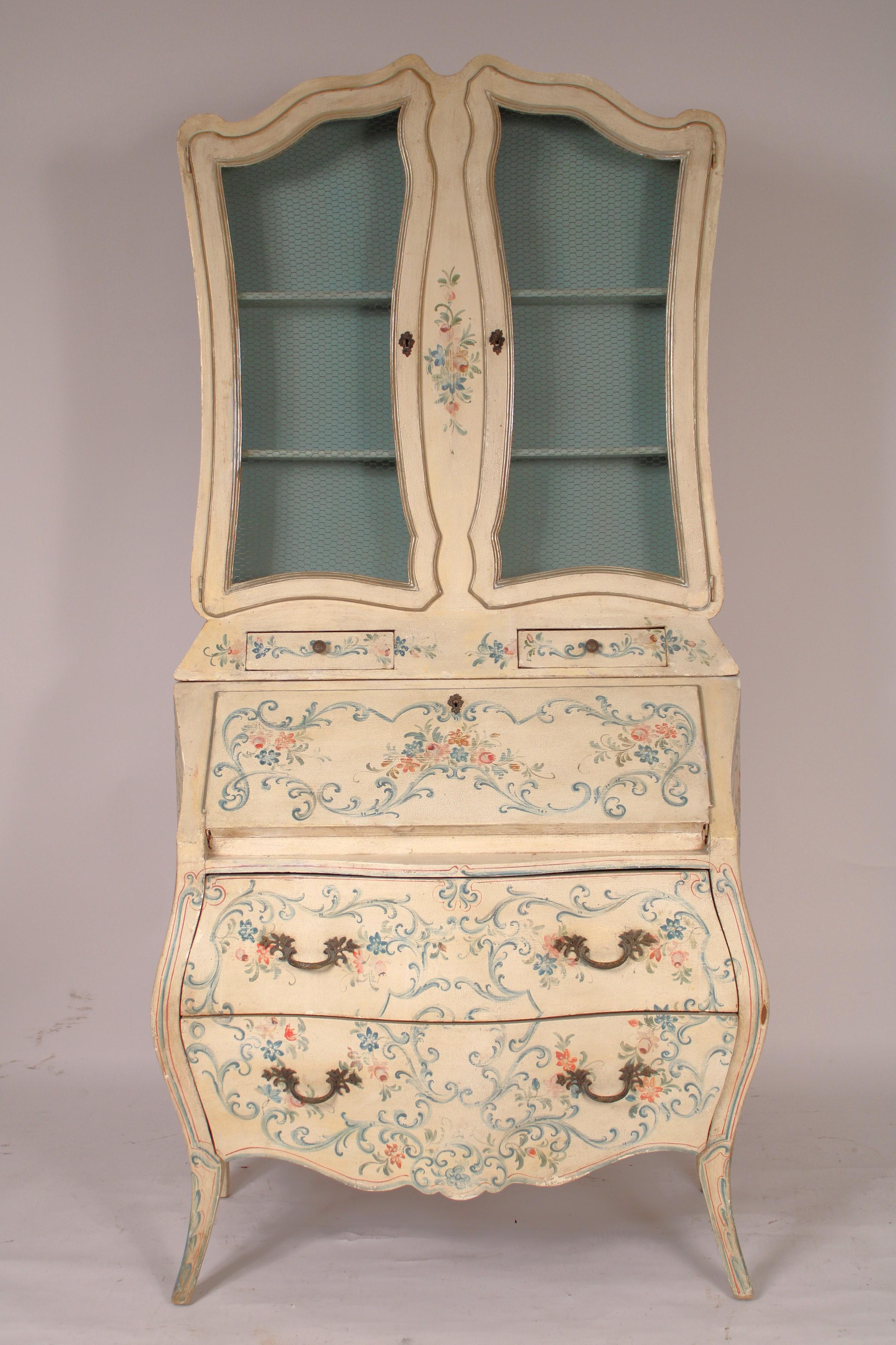 Italian Louis XV style painted bombe secretary, circa 1960's. The top section with double serpentine shaped top and two doors with birdcage wire and two shelves, the bottom section of bombe form a slant top that folds down an interior with cubby