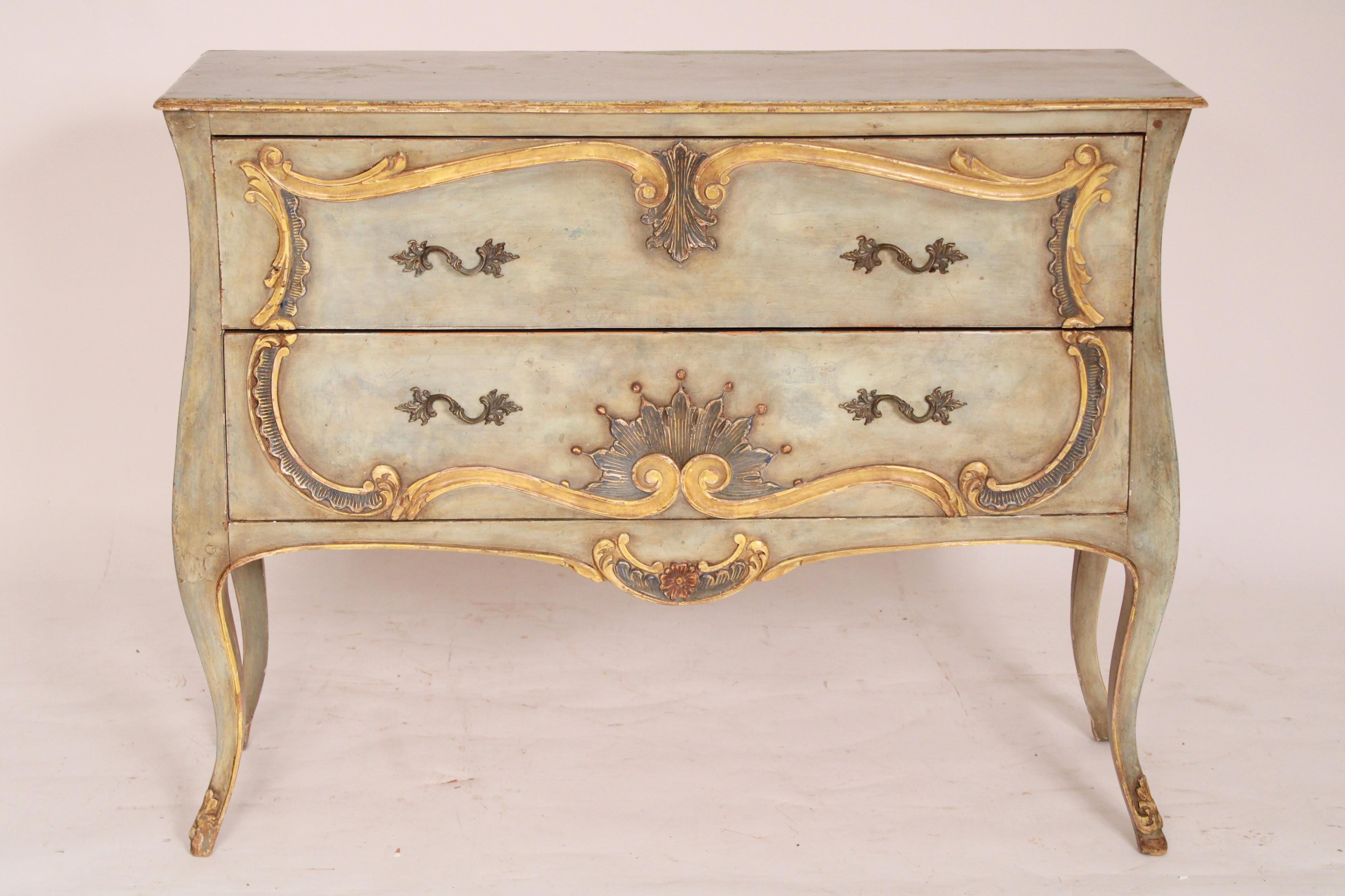 Italian Louis XV style painted chest of drawers, circa 1980's. Of slight bombe form.  With a rectangular over hanging top with molded sides and front, two drawers with carved and painted decoration and brass drawer pulls, the sides with carved and