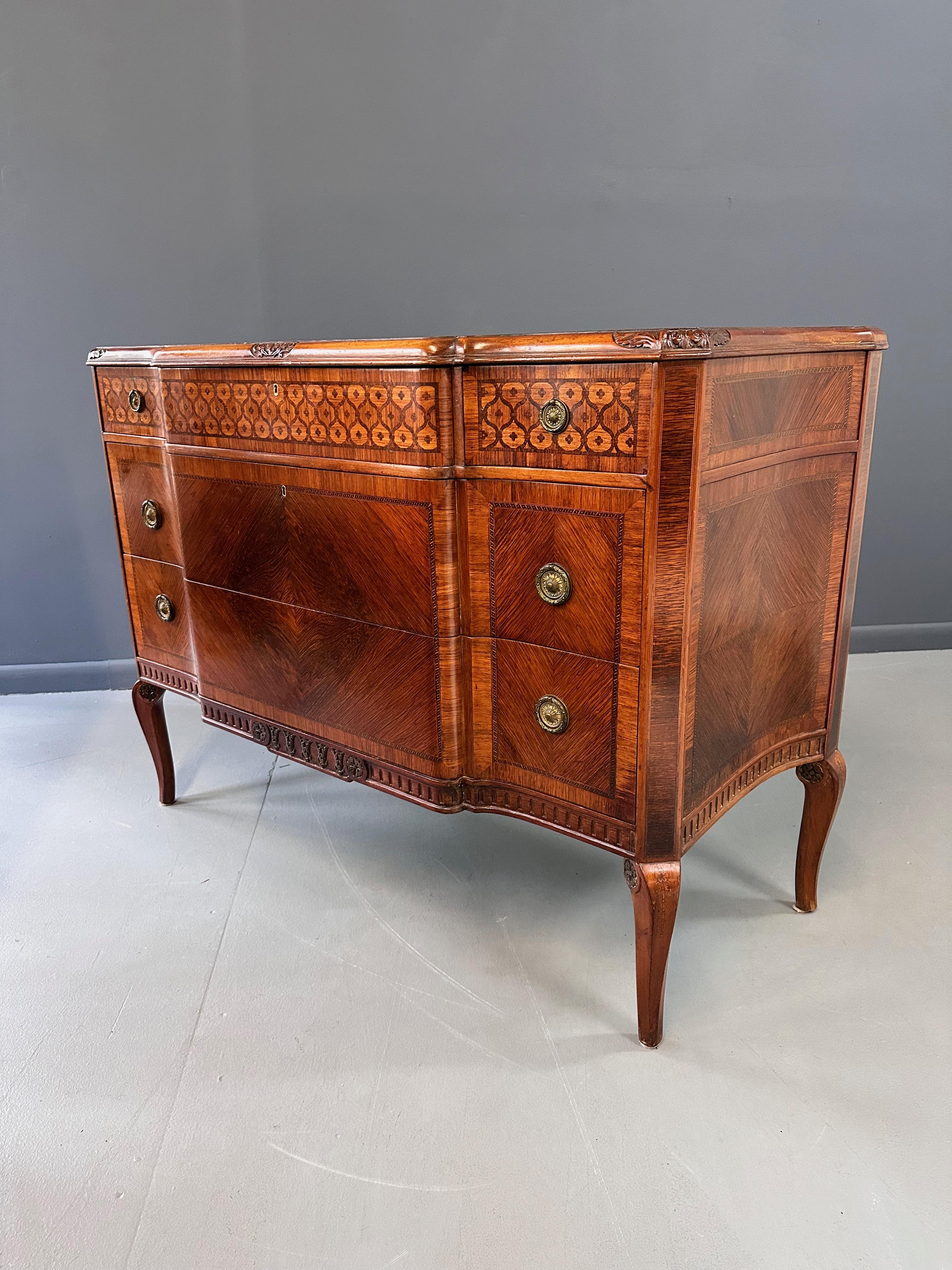 Expertly crafted in the style of Henry-François Riesener and imported from Italy by Slack, Rassnick & Co. NY in the early 1900s, this commode boasts intricate marquetry and a classic Louis XVI style. With expertly carved details and elegant lines,