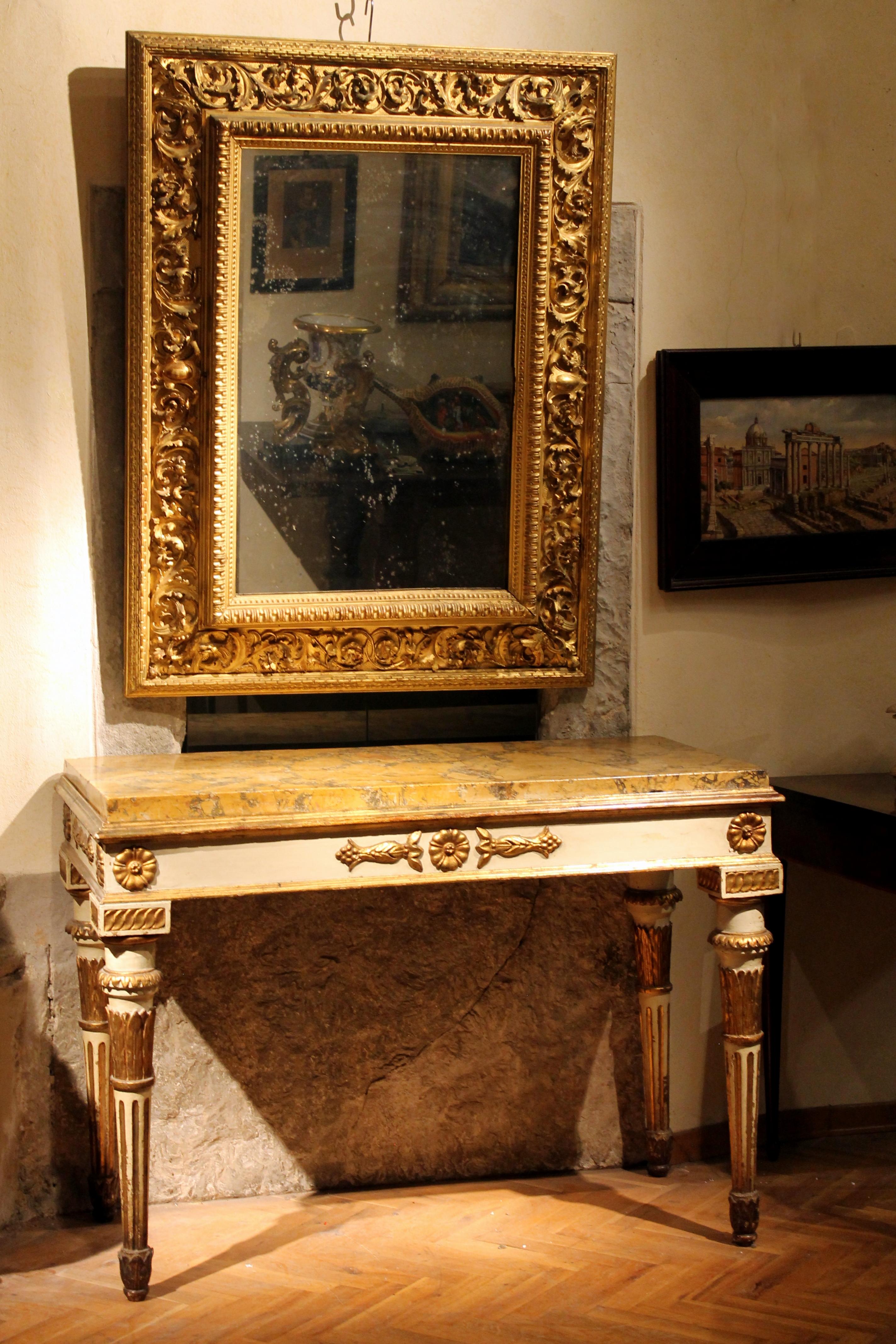 This antique Louis XVI style profusely hand carved and gilt wood frame with rectangular mercury mirror dates back to late 18th-early 19th century and was made in Northern Italy area. 
This wonderful gold leaves gilding frame features an extremely