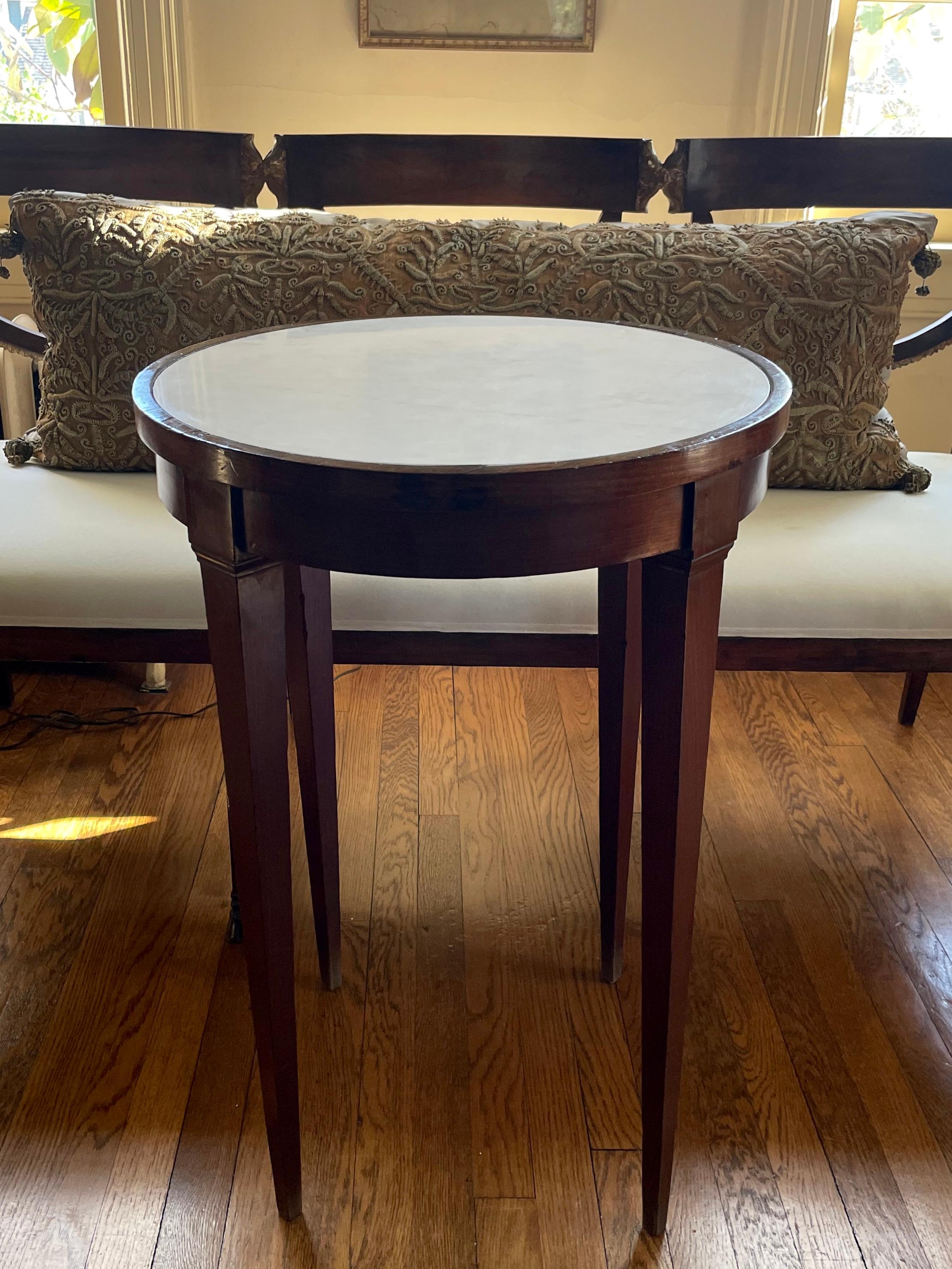 Italian Louis XVI white marble top table. Handsome and classic pared down Louis XVI cherrywood circular table with white inset marble top; elegant in traditional or modern settings due to its severely classic lines. Long streak in top is not a crack