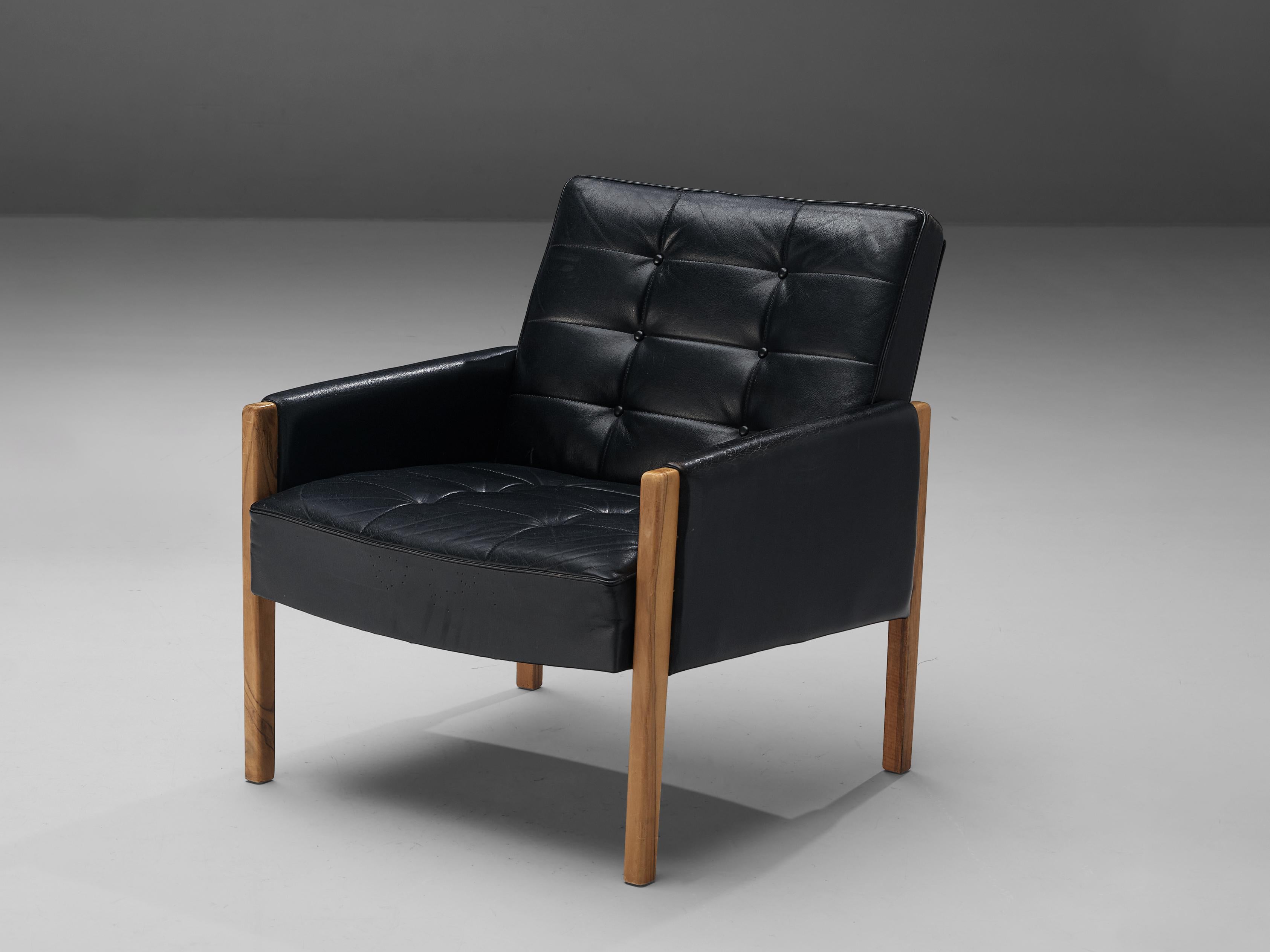 Lounge chair, leather, walnut, Italy, 1960s

A modern armchair in black leather and stained walnut, this piece features a solid wooden base with tufted leather seating gracefully placed atop the frame. The armrests, also upholstered in leather,