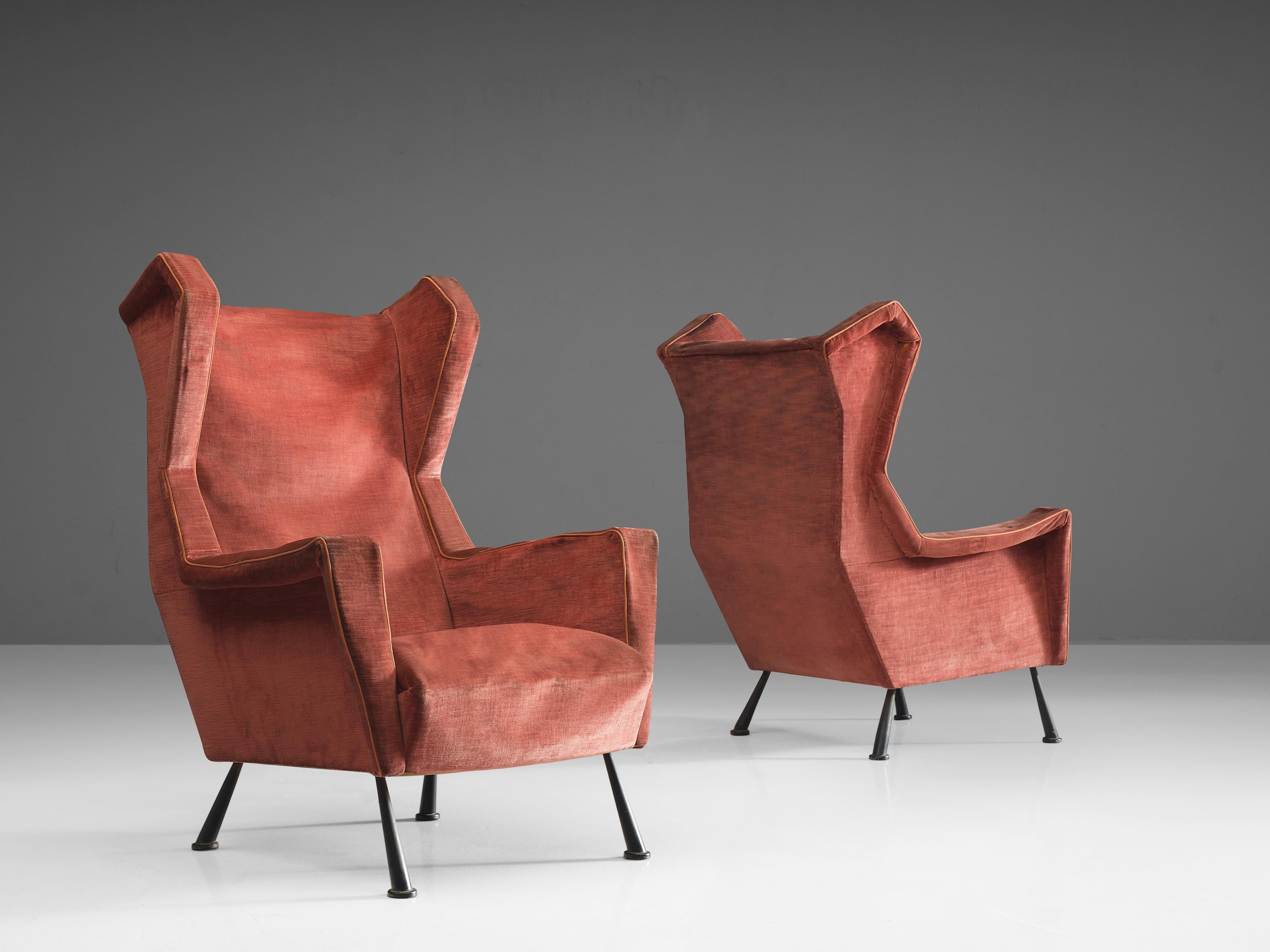 Lounge chairs, red fabric velvet, black metal, Italy, ca. 1950.

This set of angular lounge chairs is both voluptuous and grand as they are comfortable. The chairs have semi high wingbacks and feature red fabric with small tapered black metal legs.