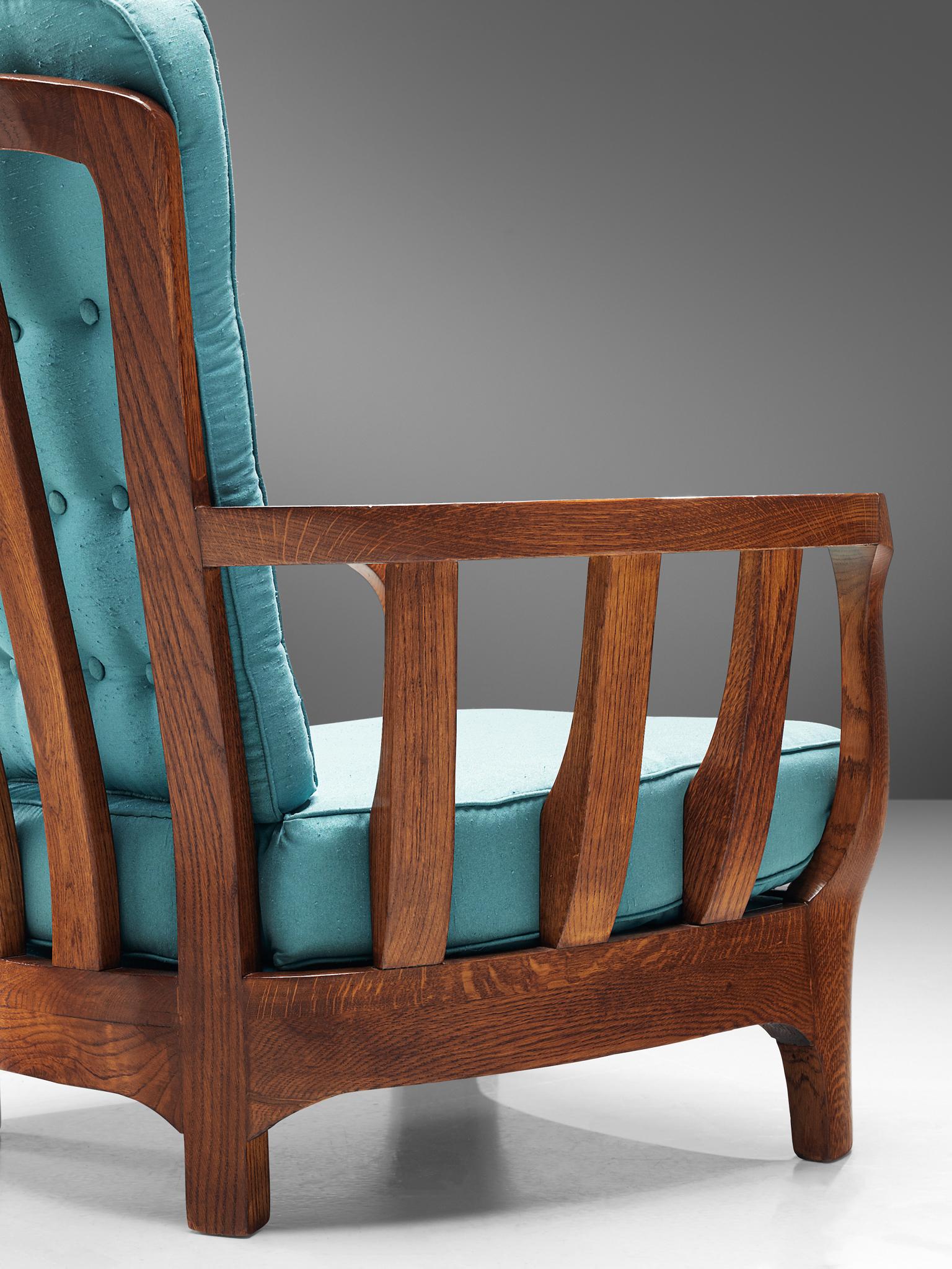 Lounge chair, oak and fabric, Italy, 1960s.

This sculptural Italian armchair is very well executed and made out of solid, carved oak. The robust chair feature wonderfully curved armrests with slats. The high back features an interesting open