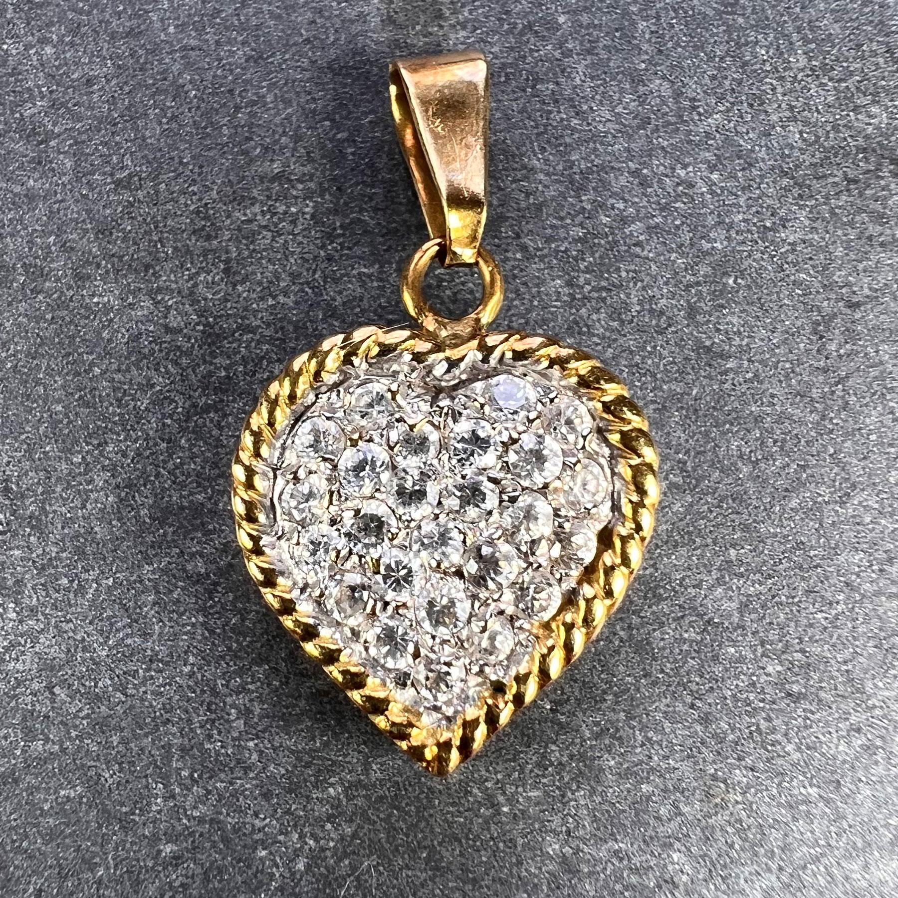 Un pendentif italien en or jaune et blanc 18 carats (18K) conçu comme un cœur d'amour serti de 25 diamants blancs ronds de taille brillant avec un poids total approximatif de 0,75 carat. Estampillée 750 pour l'or 18 carats et la fabrication