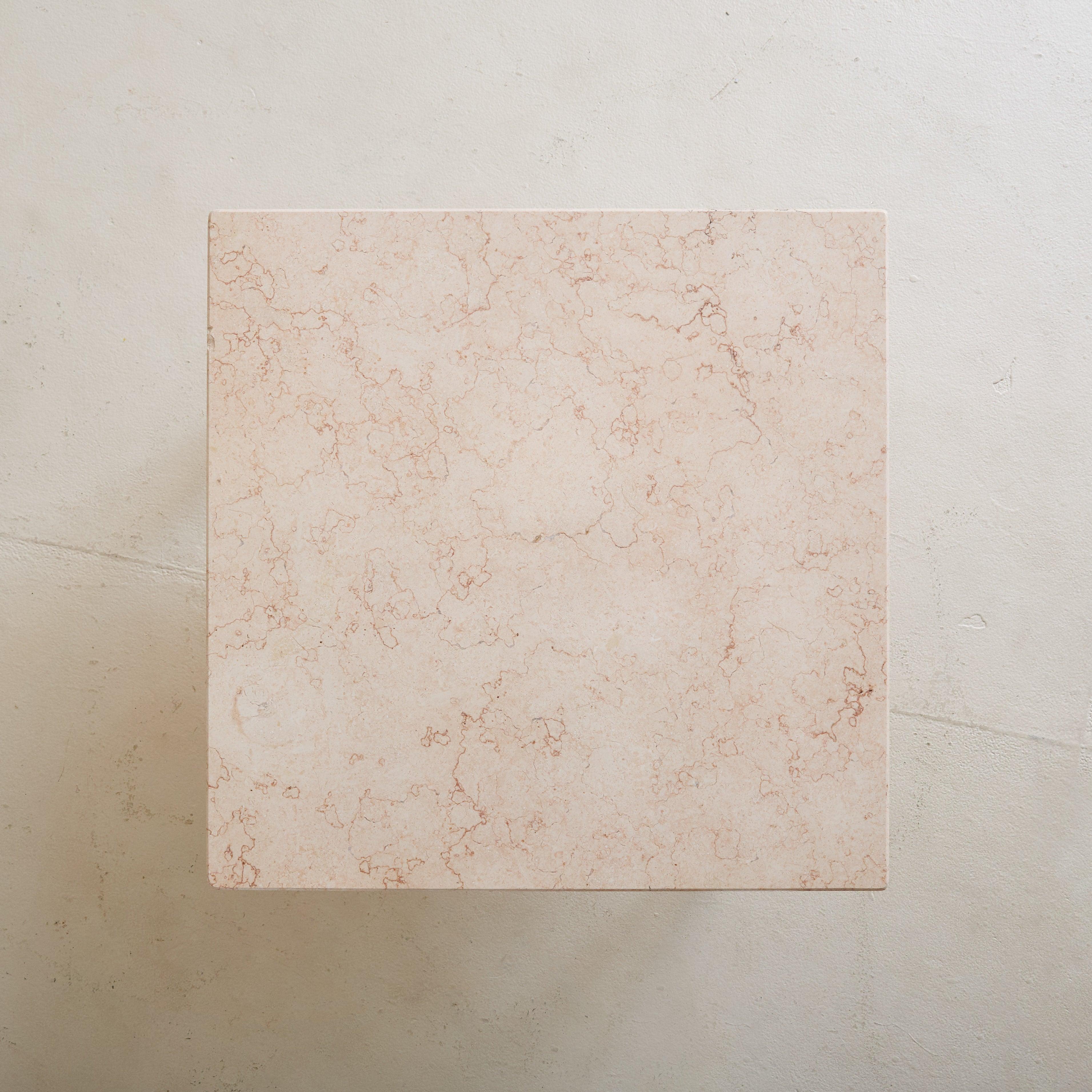 A 1950s Italian low square side table, featuring a peach-hued honed marble top with delicate terracotta veining. It rests on a minimalist brass base, characterized by tapered legs and rounded feet.

Sold and priced individually.

Condition: In good