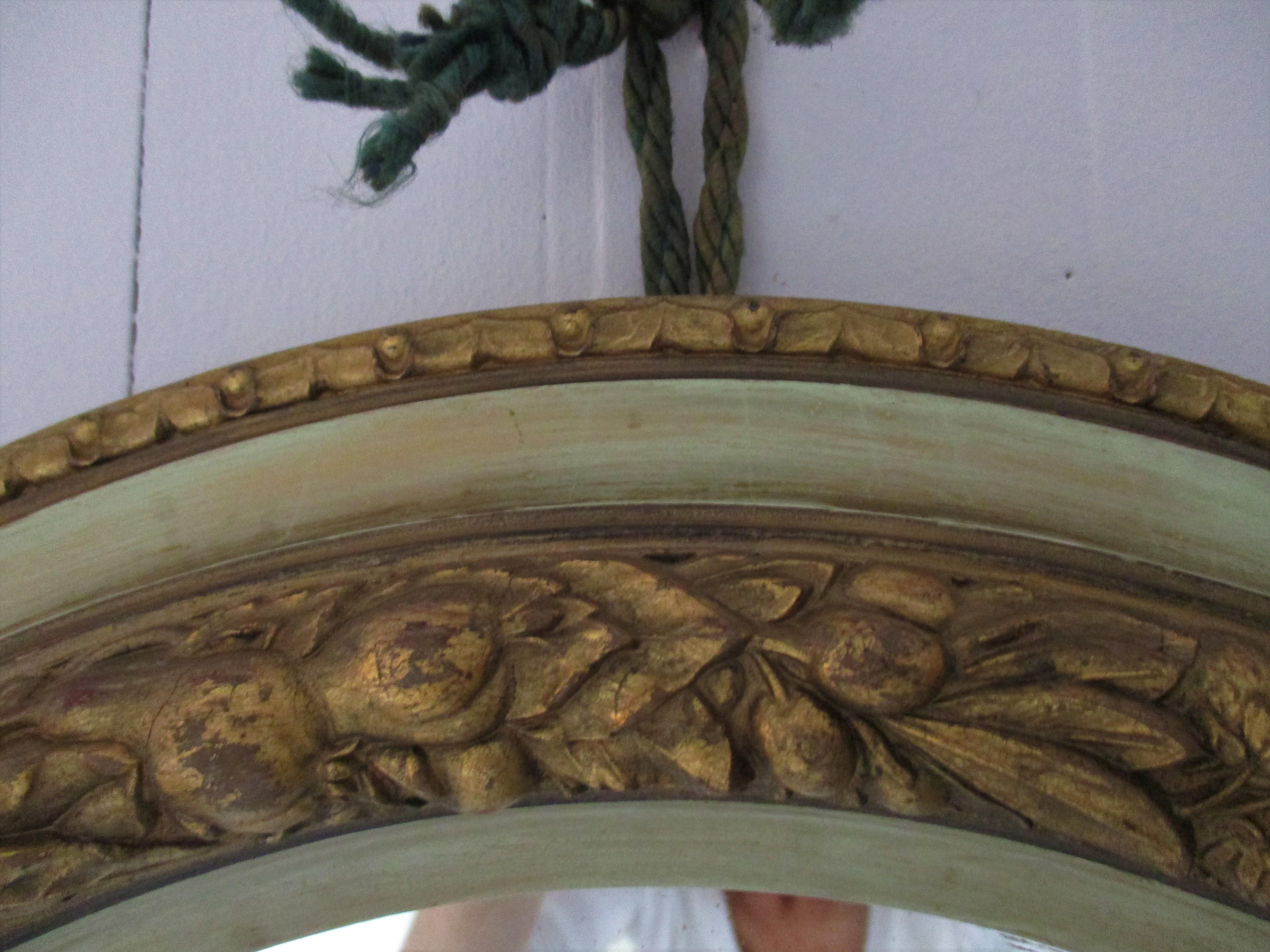 Beautifully unique 19th century Italian oval mirror with an intricate carved cornucopia design in gilt surrounding the mirror.