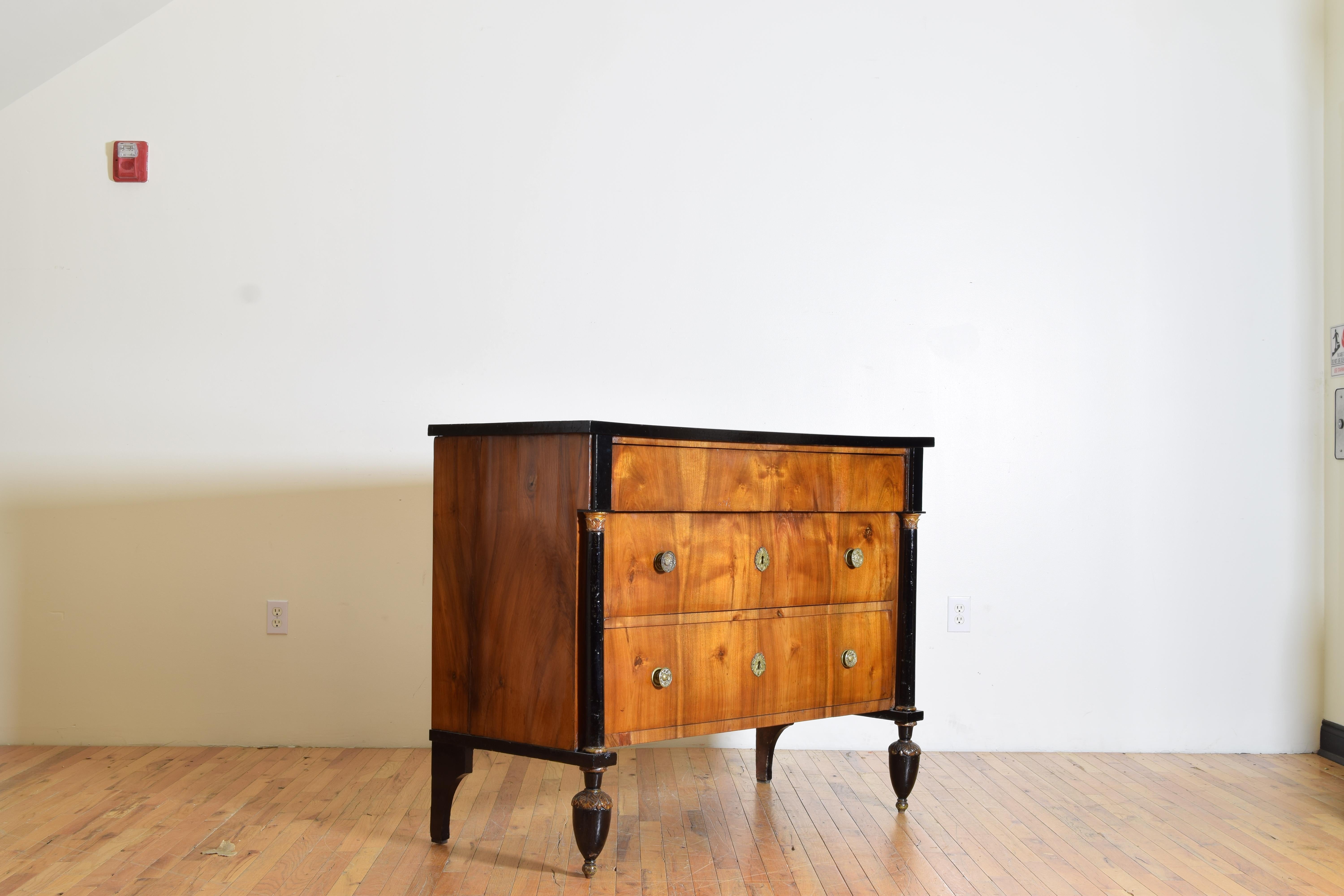 Having a rectangular top with ebonized edge, the conforming case below housing three drawers with the top drawer being somewhat hidden, the pilasters flanking the drawers are ebonized with carved giltwood capitals and bases, the wonderful feet are