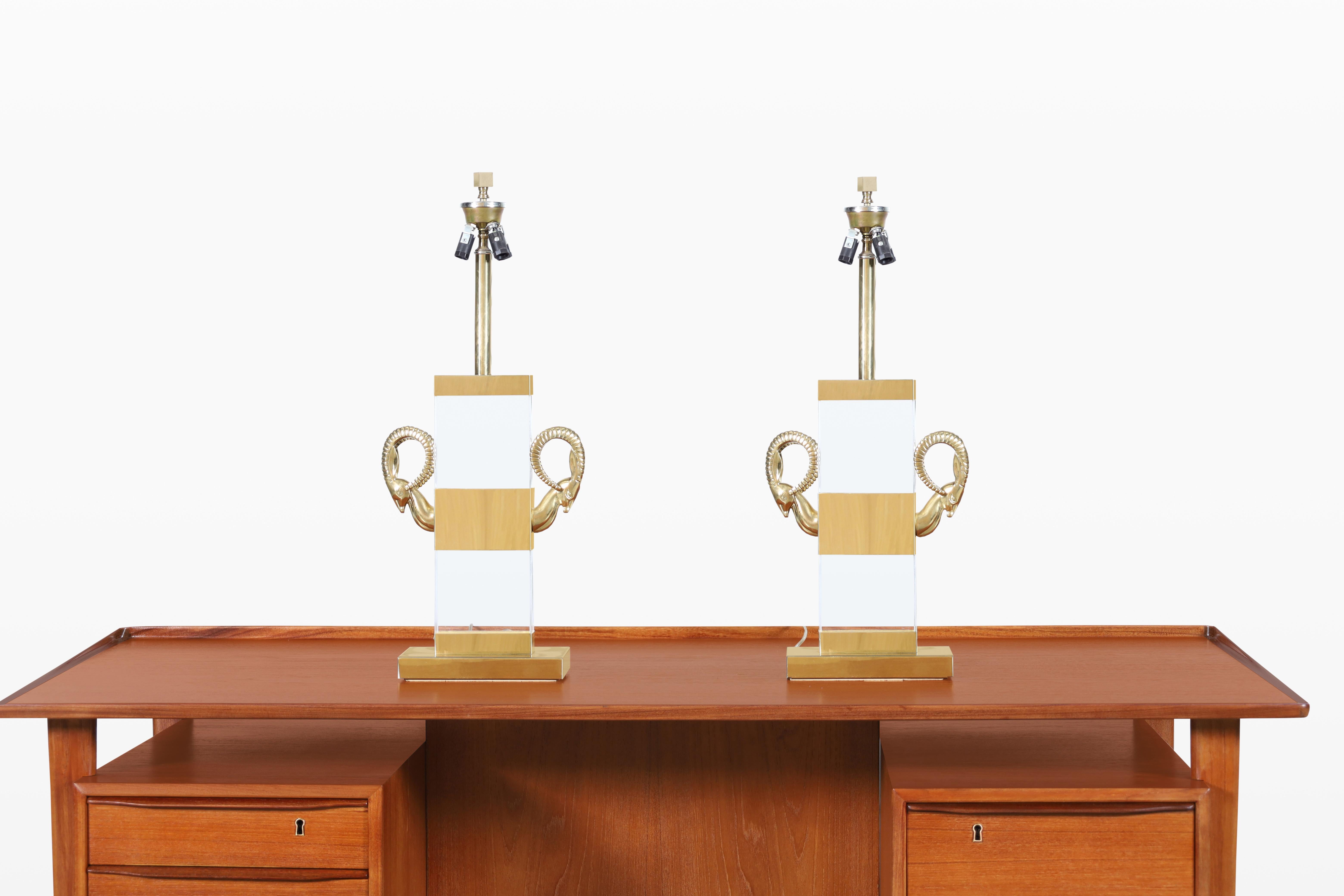 Imagine adding a touch of elegance and glamour to your space with this stunning pair of vintage Hollywood Regency table lamps, crafted in Italy during the 1970s. These lamps are truly a statement piece, featuring exquisite solid brass ram's heads