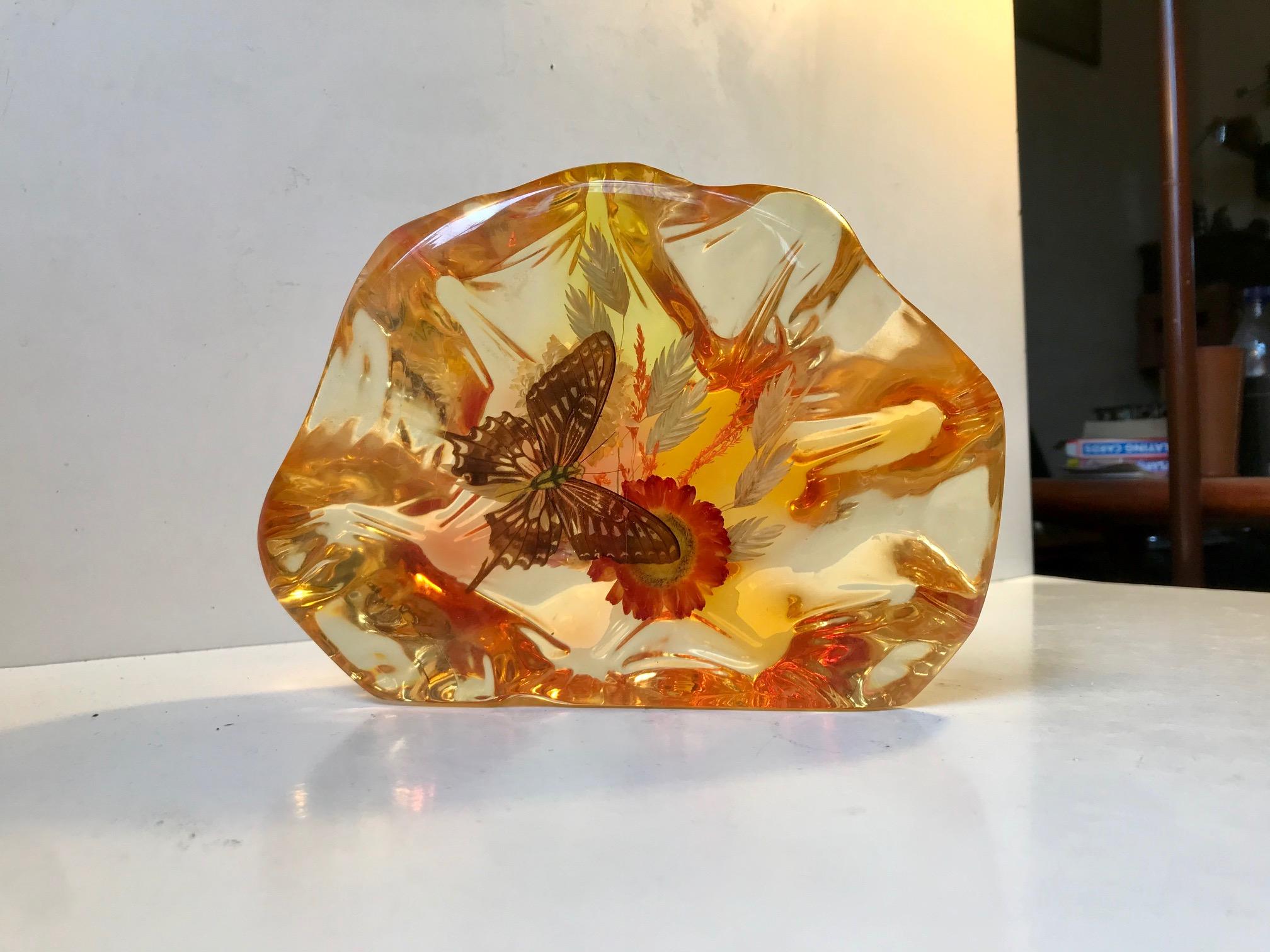 Decorative micro-cosmos in translucent sculpted Lucite. Encapsulated arrangement with flowers and a butterfly. handmade in Italy during the 1960s by an anonymous maker/craftsman. Suitable as a desk sculpture or bookend.