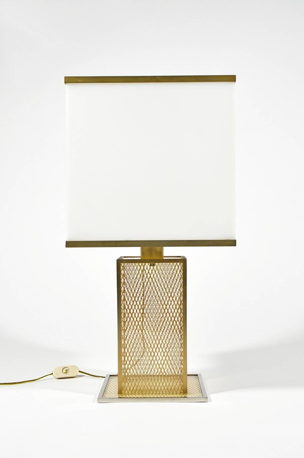 Italian table lamp manufactured circa 1970, in the style of Romeo Rega or Willy Rizzo, featuring a white Lucite shade with brass details and a body made of transparent Lucite with brass grid inclusion.