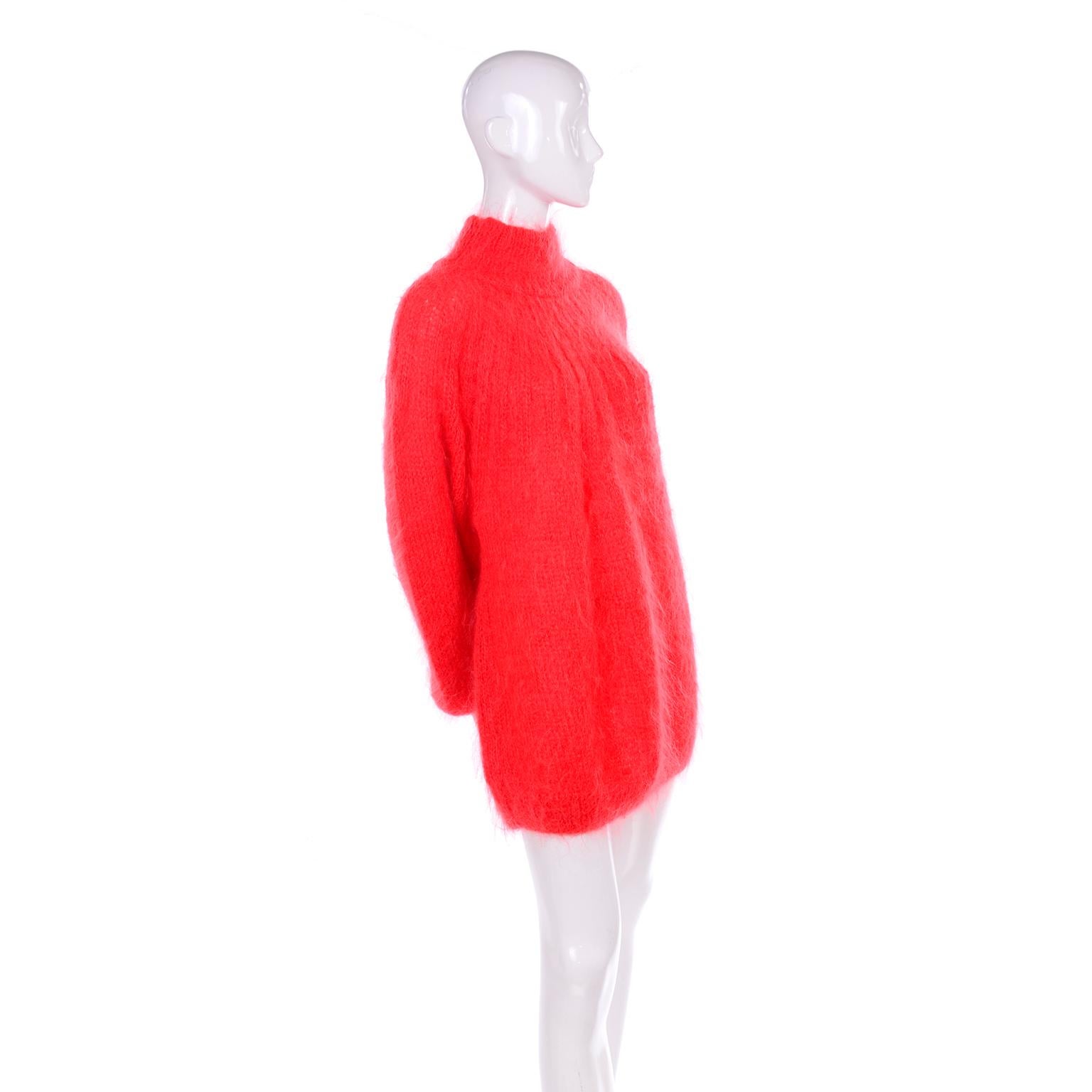 This is a gorgeous, extremely soft mohair and wool blend sweater, with an oversized fit that makes this work as either a sweater or we love it when it's worn as a sweater dress! This 1980's deep coral sweater has ribbing down the front and a high