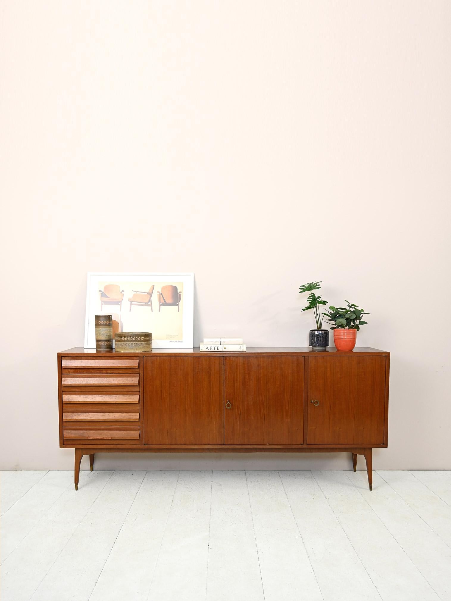 1960s teak sideboard with drawers.

Elegant piece of furniture of Italian origin with important dimensions, measuring in fact 205 cm.
Consisting of 5 drawers and two compartments closed by hinged doors equipped with a lock.
The wooden handle of