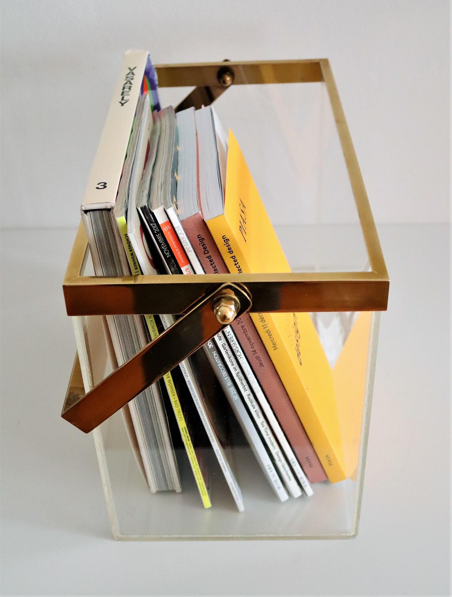 Gorgeous magazine holder or magazine rack made of solid Lucite material with shiny brass details, Made in Italy in the 1970s.
This basket is multi-purpose and can be used of course for many different objects.
Due to its size it keeps quite a big