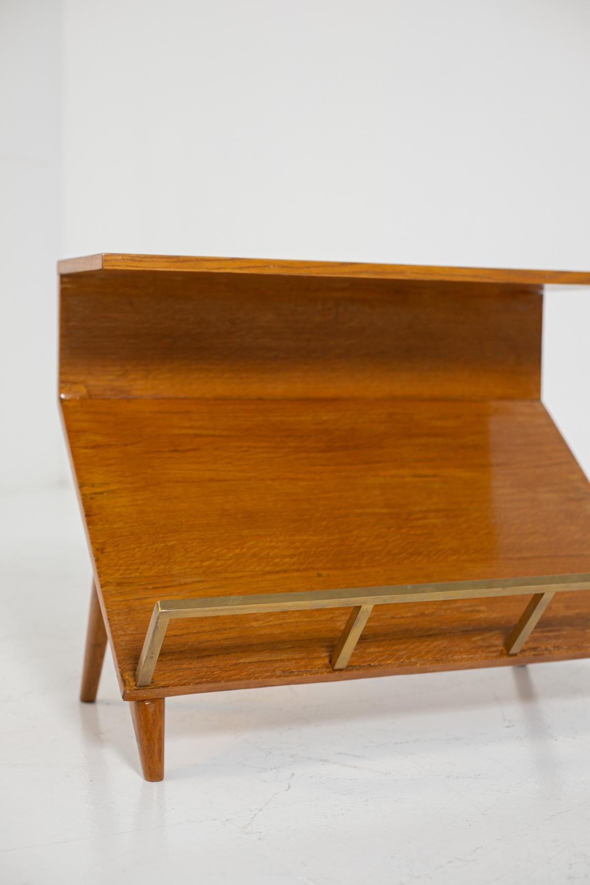 Wood and brass magazine rack by Marco Zanuso, 1950s. The magazine rack has a dual function through its support surface, in fact it can also serve as a small table placed next to a sofa. The magazine rack is made of wood with angles and sharp
