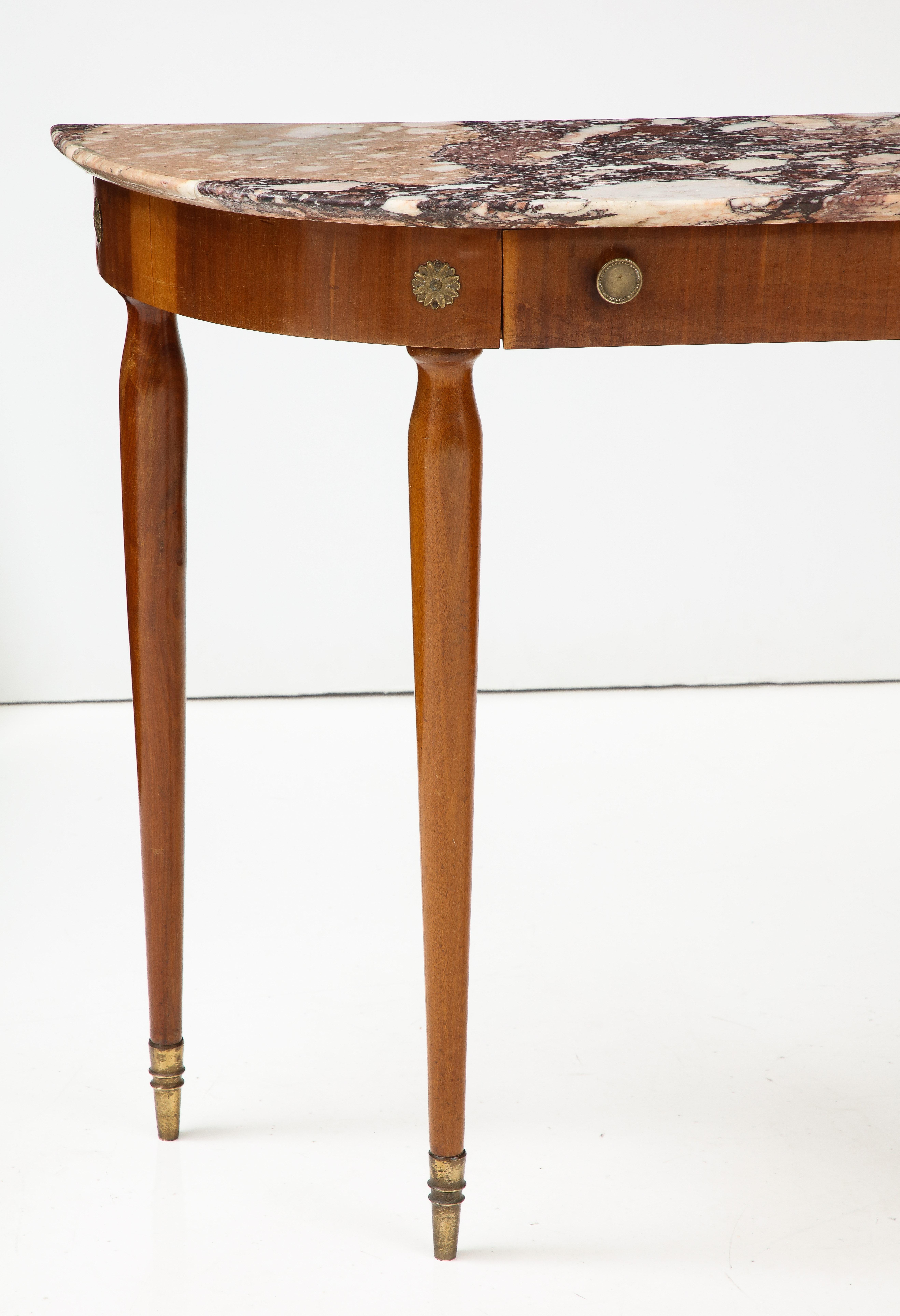 A fine Neoclassical Italian 1940's mahogany console table.   The splendid marble top rests on an apron with with a single front drawer with brass pulls and brass rosettes decorating the sides.  The whole supported by elegantly rounded and tapered