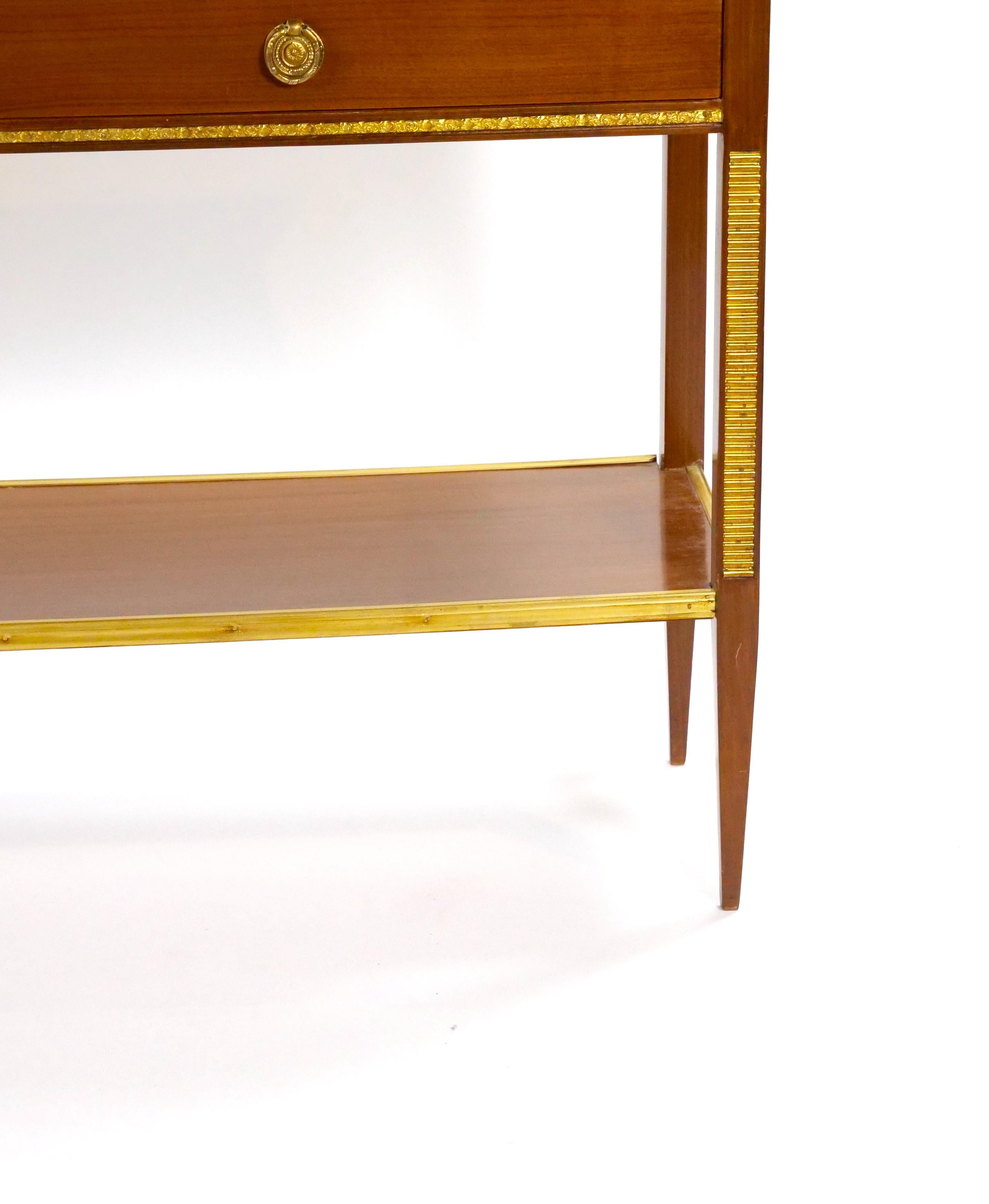 Elégante et intemporelle, cette table de hall en acajou italien respire la sophistication et la polyvalence. Fabriquée entre le milieu et la fin du XXe siècle, elle présente un design néoclassique raffiné avec des détails sculptés à la main et des