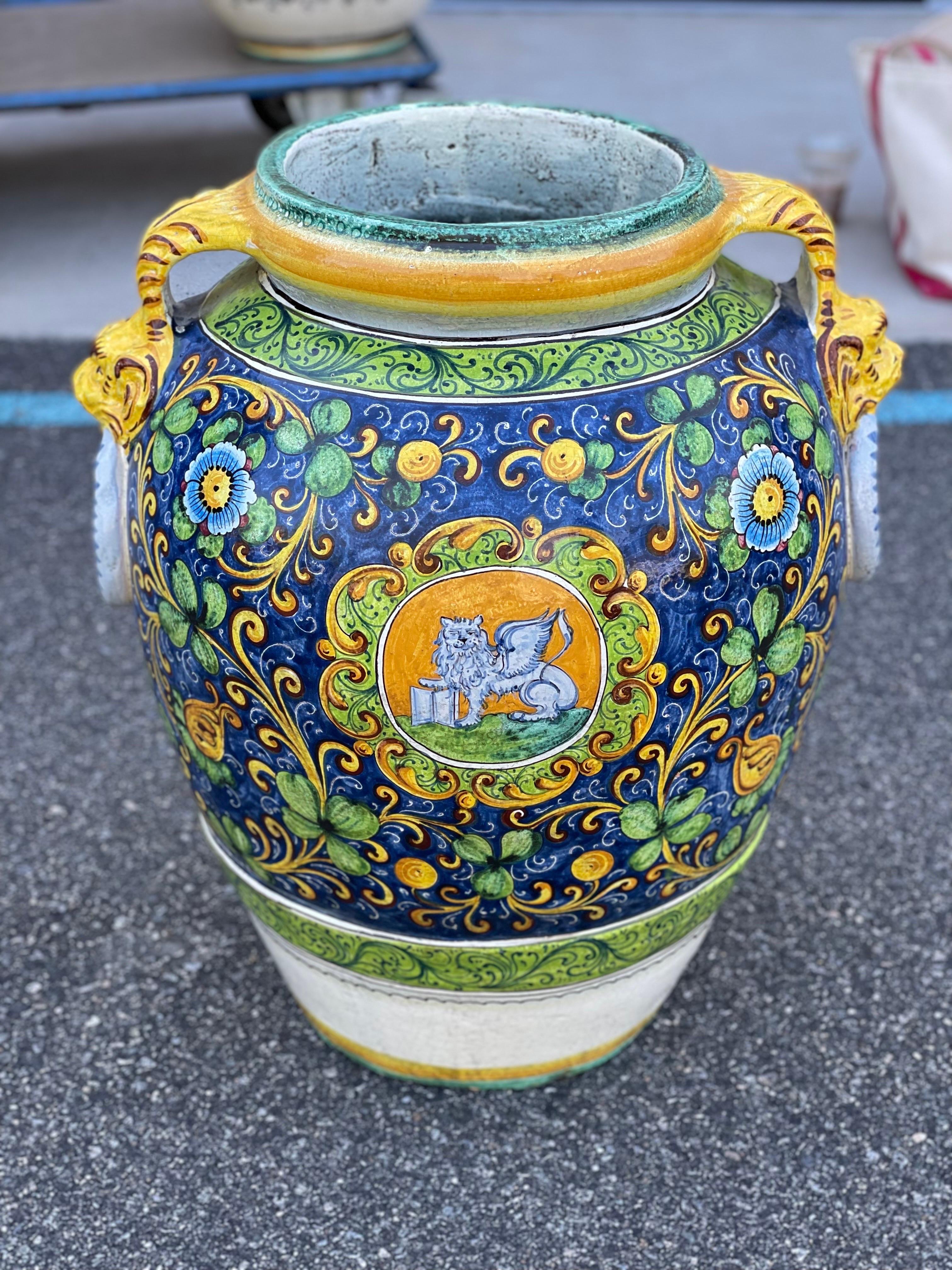 Pot italien en maïolique peint
Un grand pot à fond bleu, bras à glaçure jaune avec des anneaux bleus accrochés de chaque côté. Très bon état.
20ème siècle, Italie.

Mesures : 19
